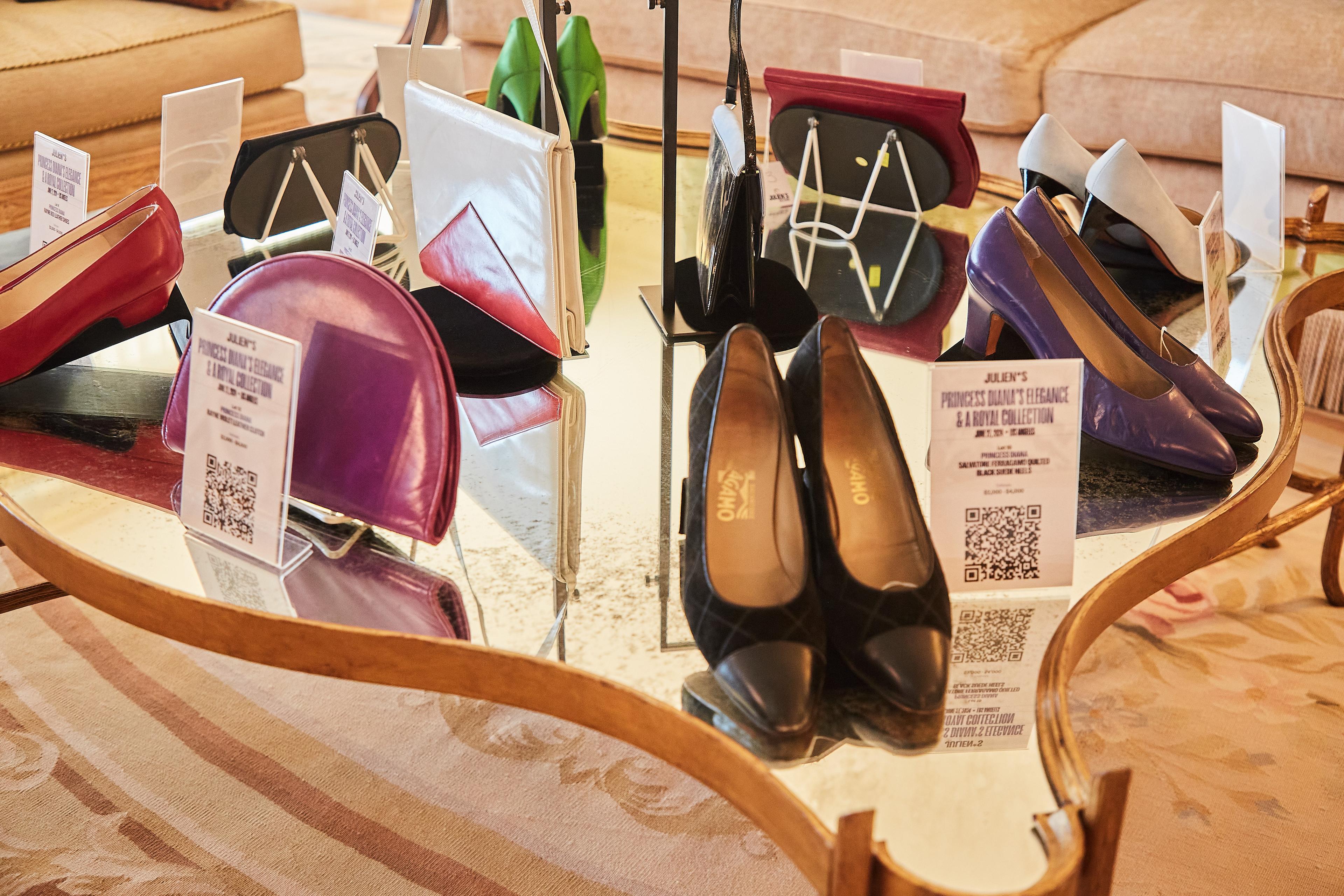 a table with a lot of shoes and handbags on it .