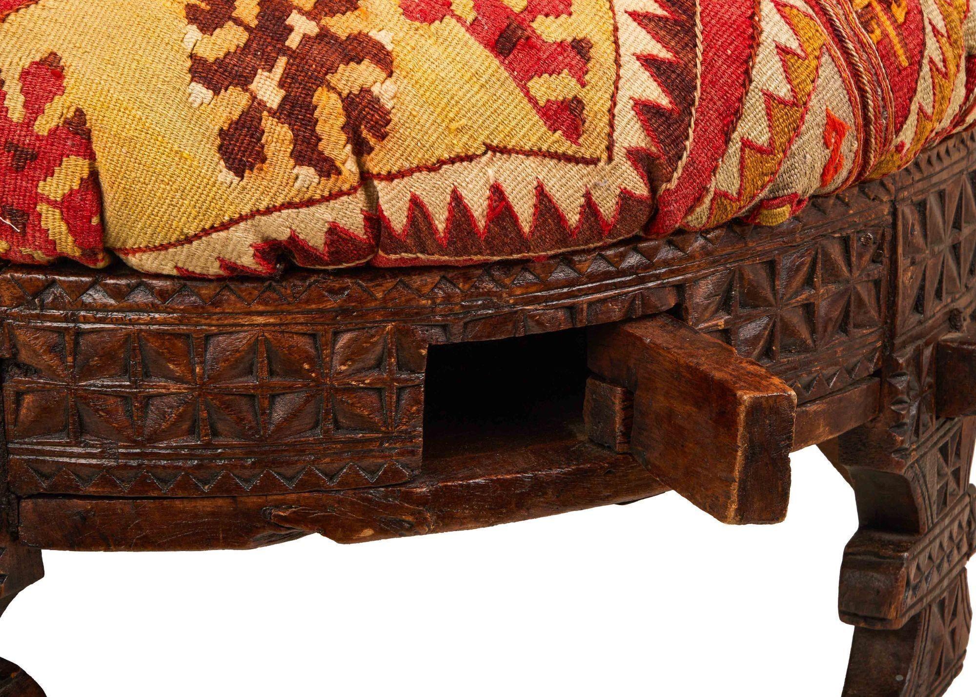 a close up of a wooden stool with a rug on it .