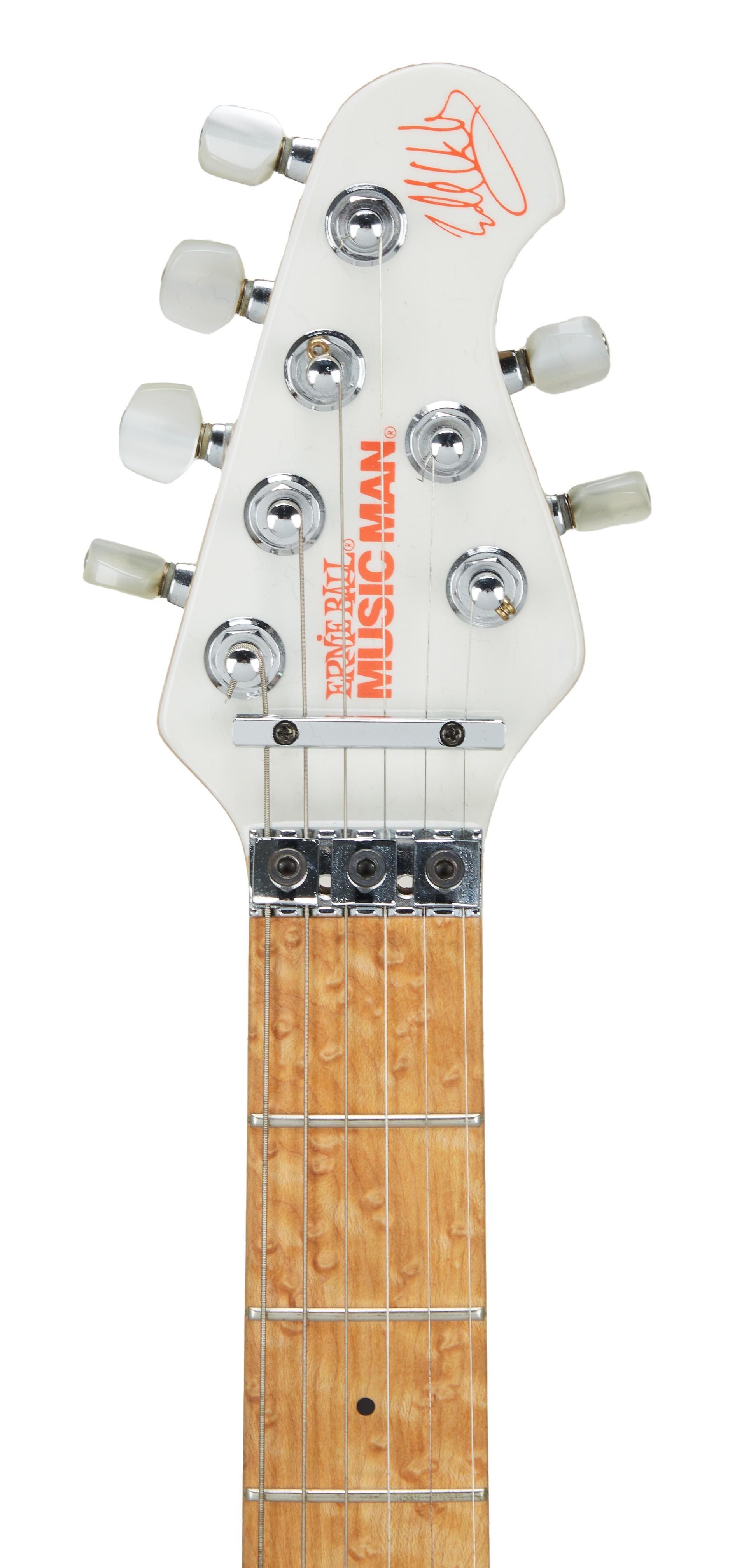 the headstock of a white ernie ball musicman guitar