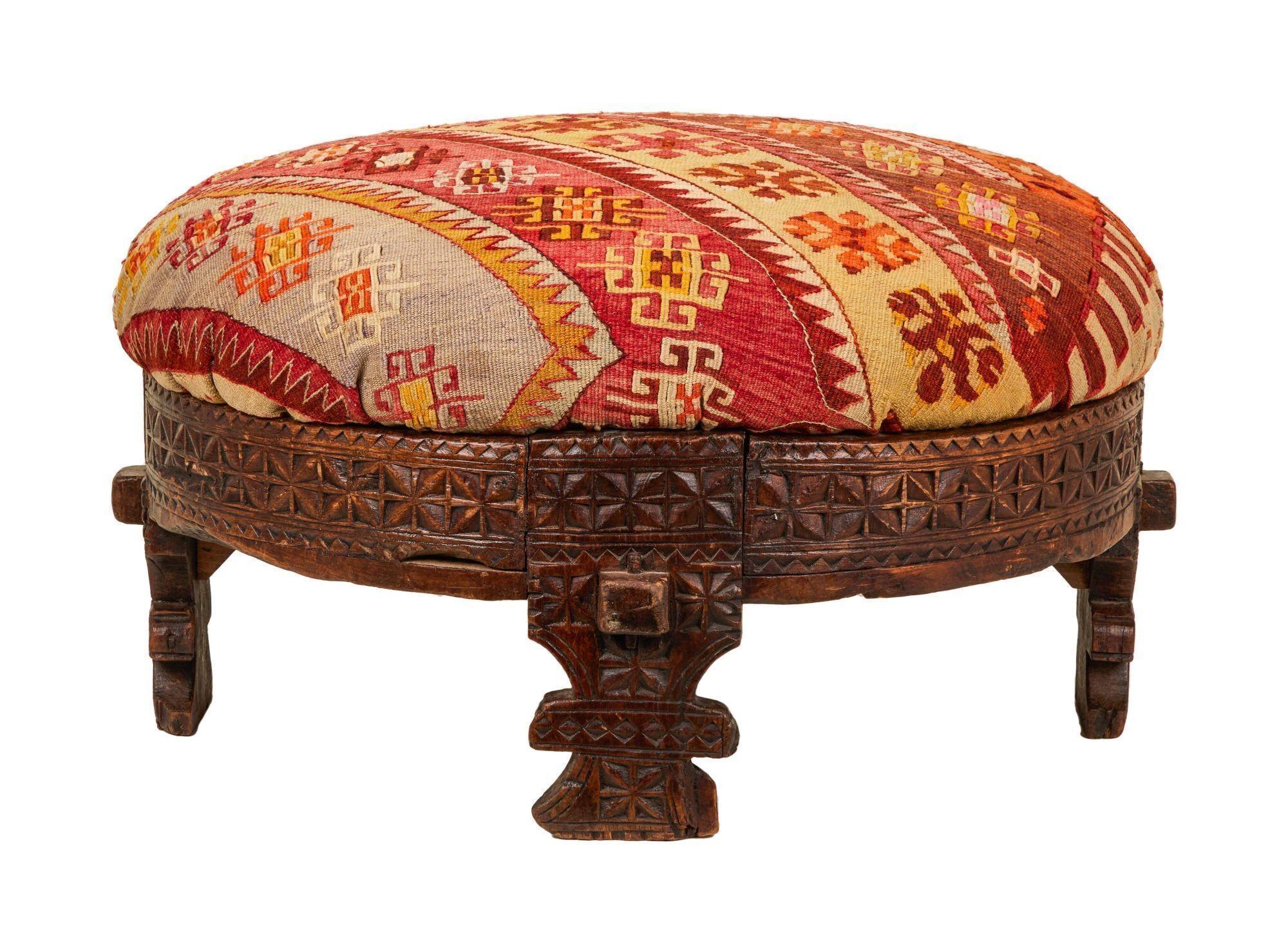 a colorful ottoman with a wooden base on a white background