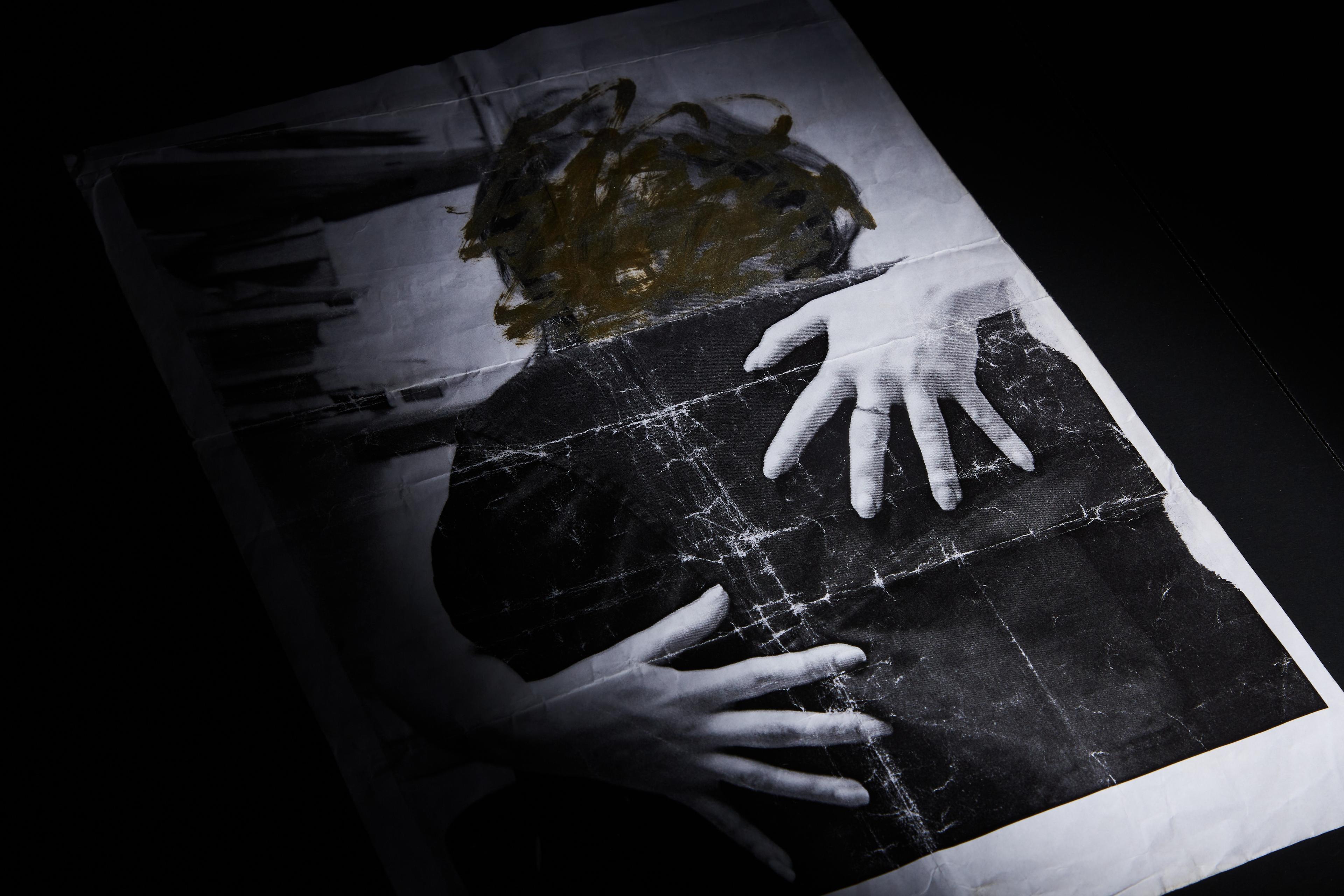 a black and white photo of a person 's hands on a piece of paper .