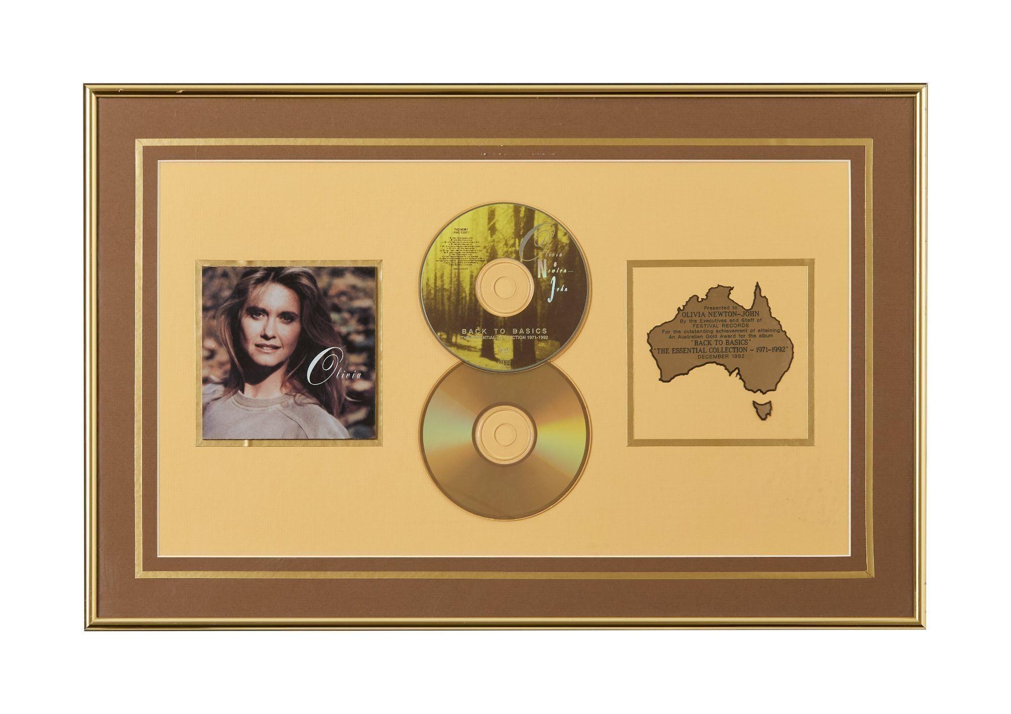Lot #14. Olivia Newton-John | Record Award for "Back to Basics" a framed cd with a picture of a woman and a map of australia .