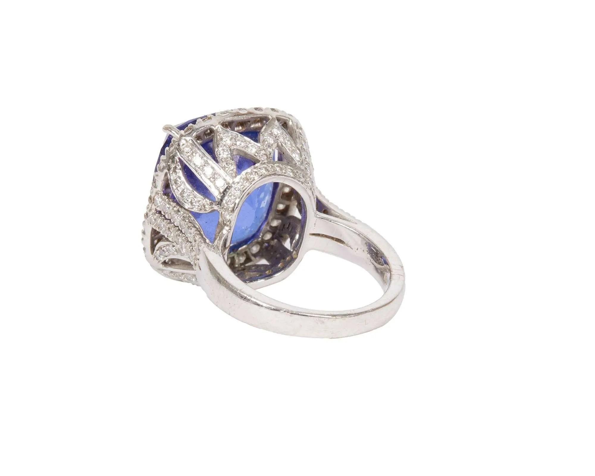 White gold ring with a large cushion-cut blue tanzanite gemstone surrounded by diamonds.