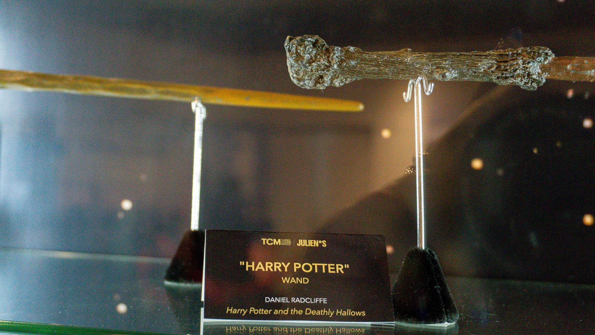 two harry potter wands are on display on a glass shelf .