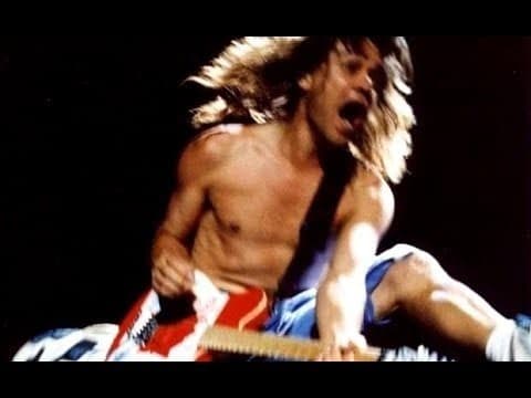 a shirtless man is playing an electric guitar on a stage .
