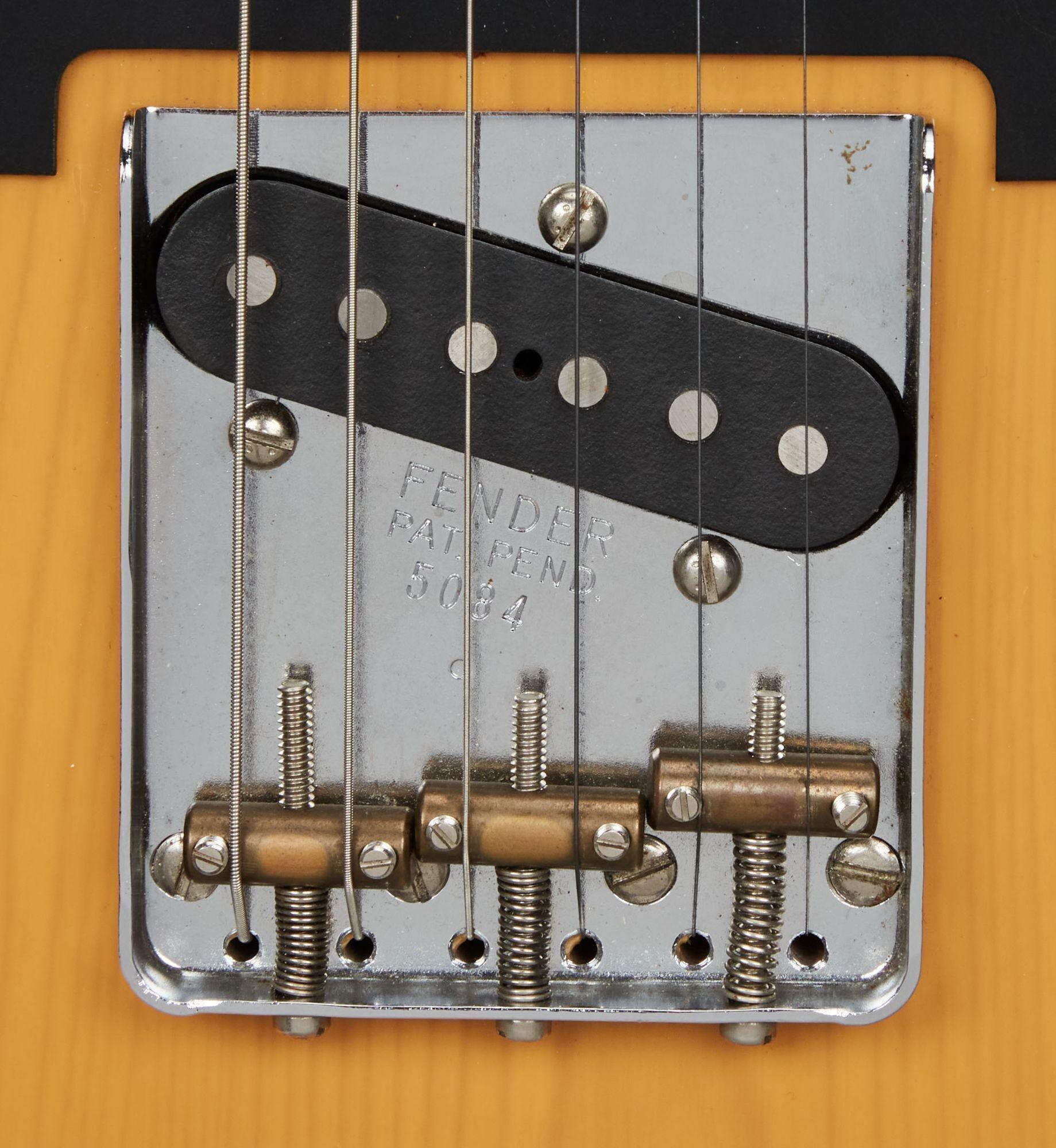 a close up of a fender guitar bridge