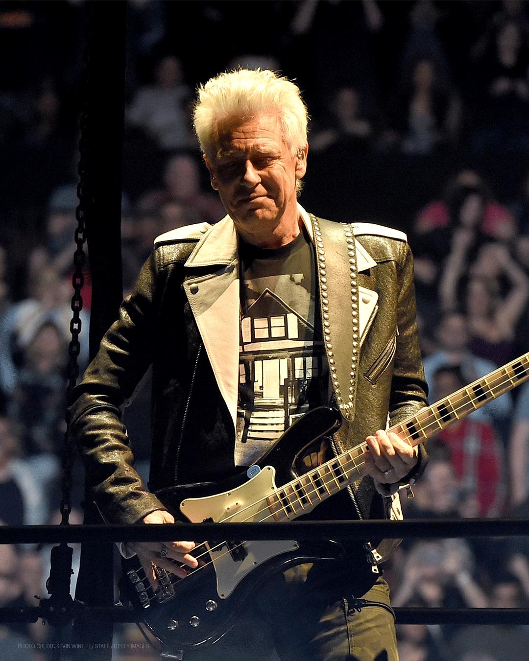 a man is playing a guitar on a stage