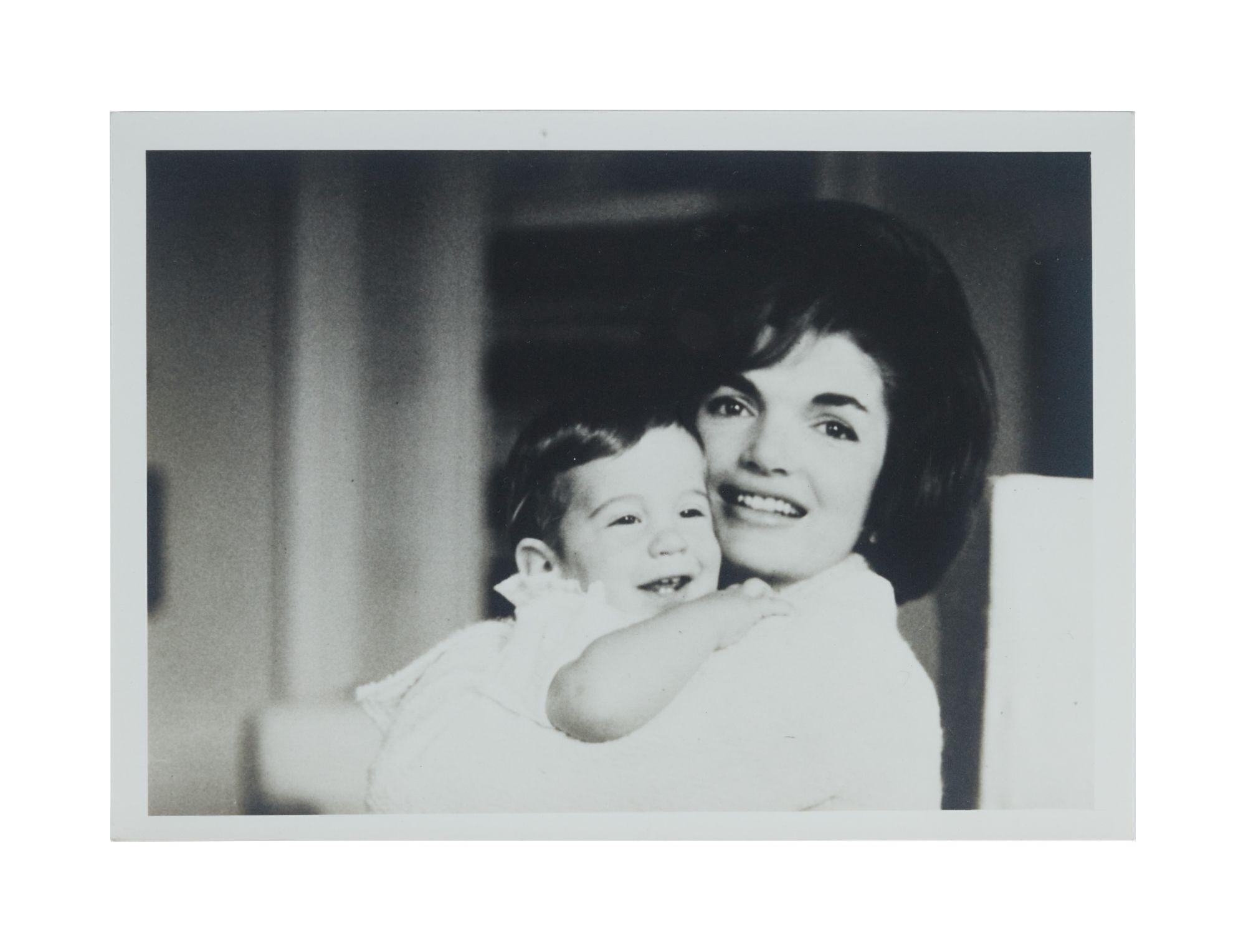 a black and white photo of a woman holding a child .
