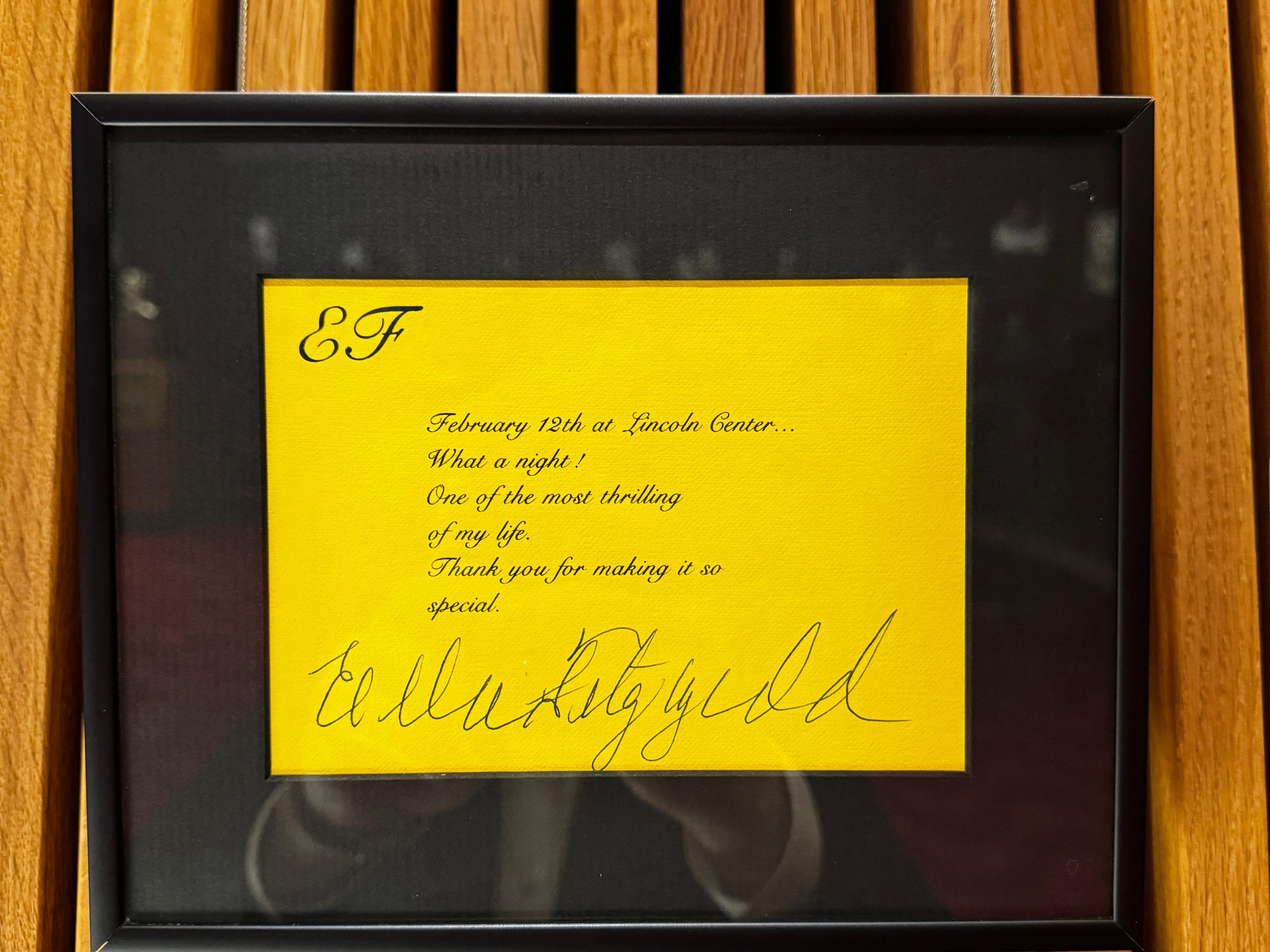 A framed yellow piece of paper on a black background