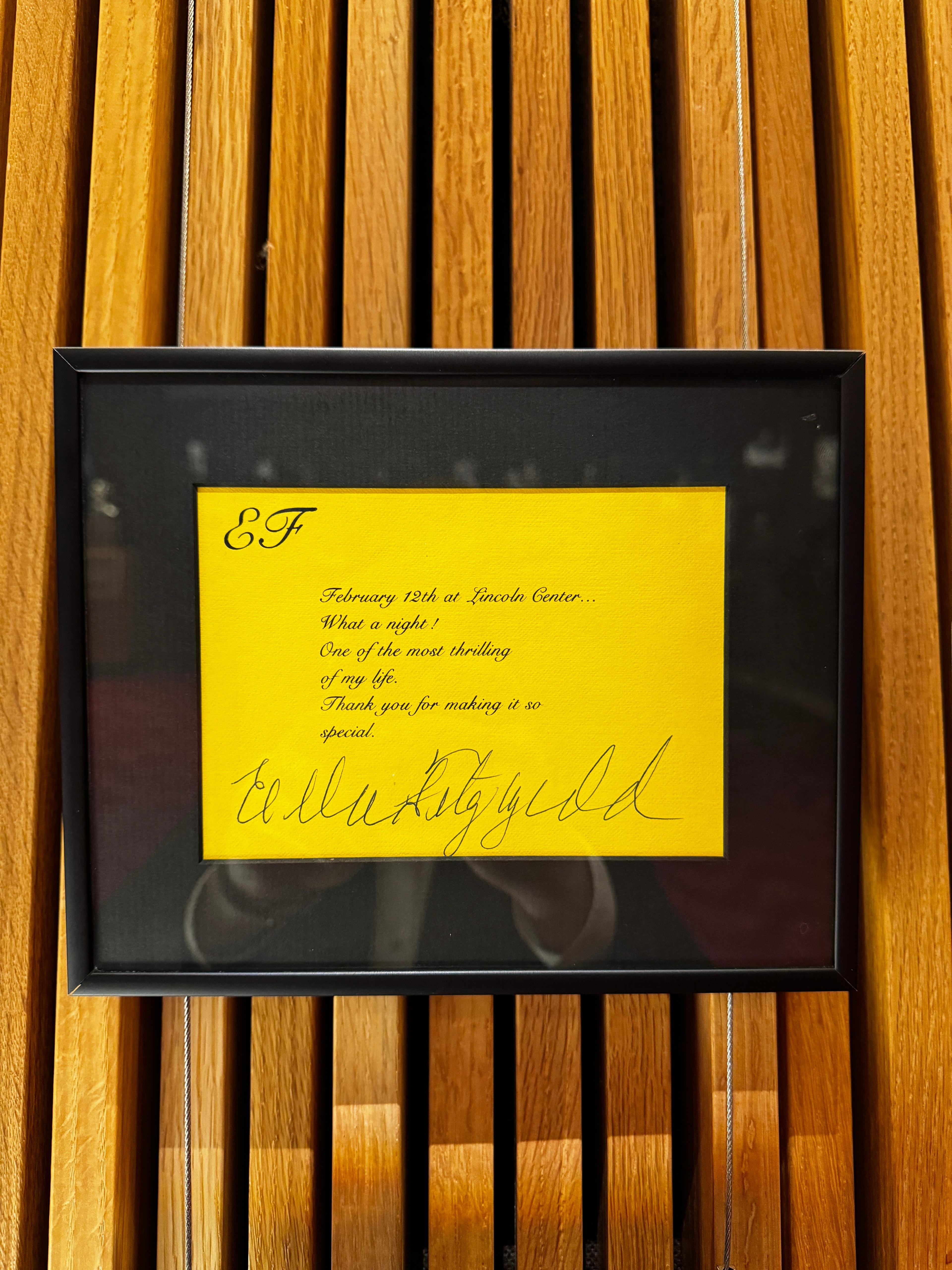 A framed yellow piece of paper on a black background