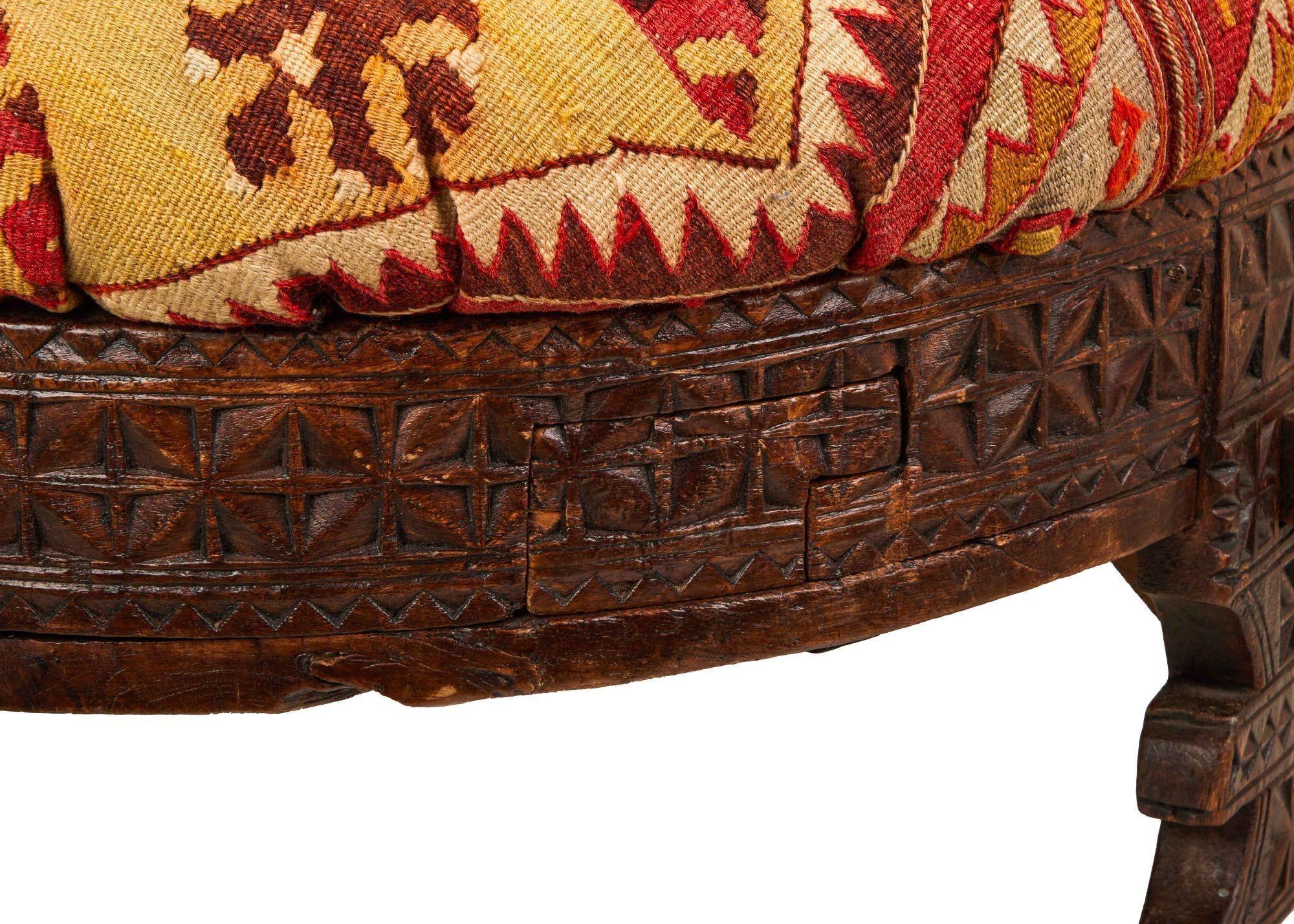 a close up of a wooden chair with a rug on it .