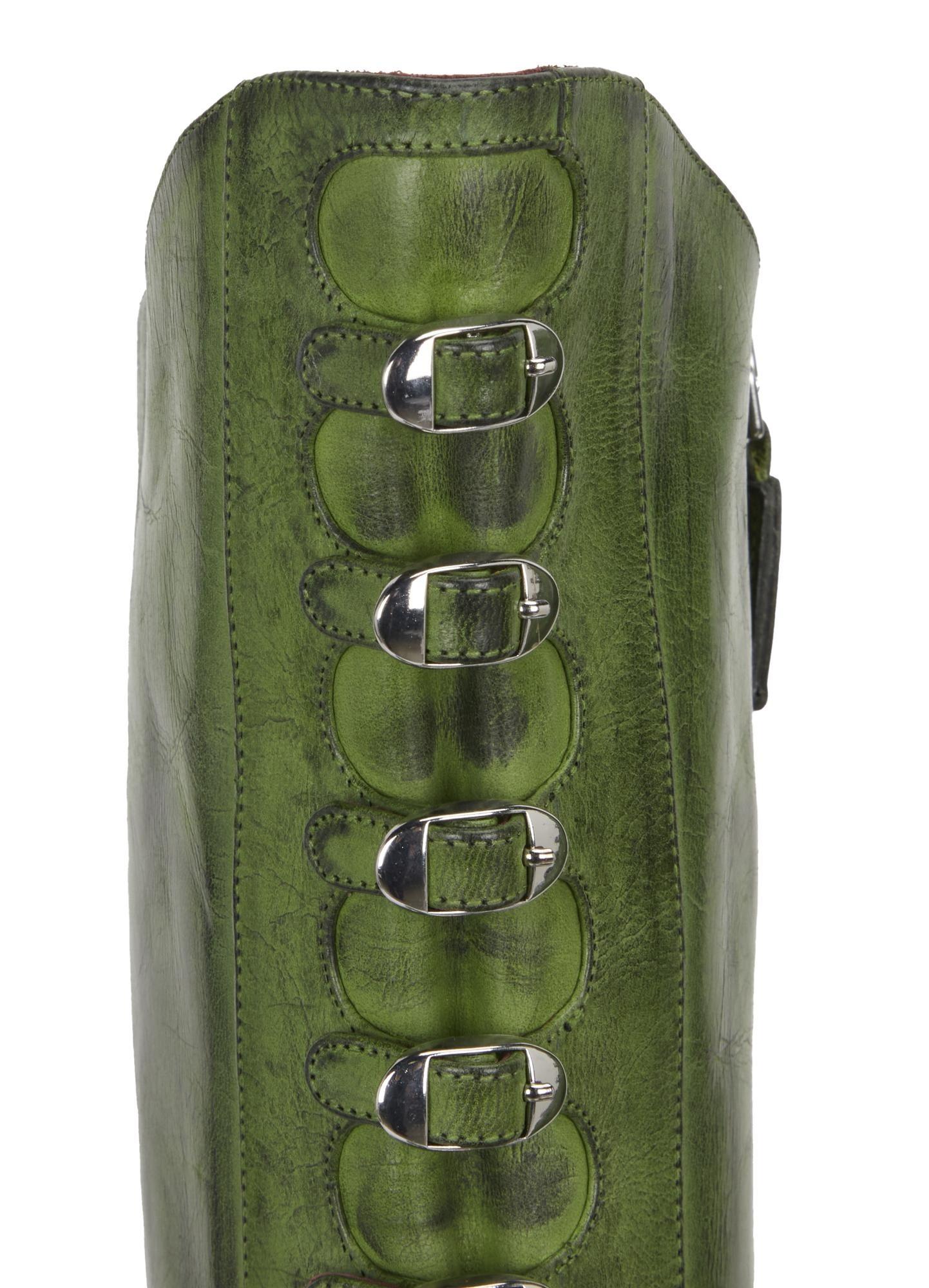 a green leather boot with silver buckles on the side