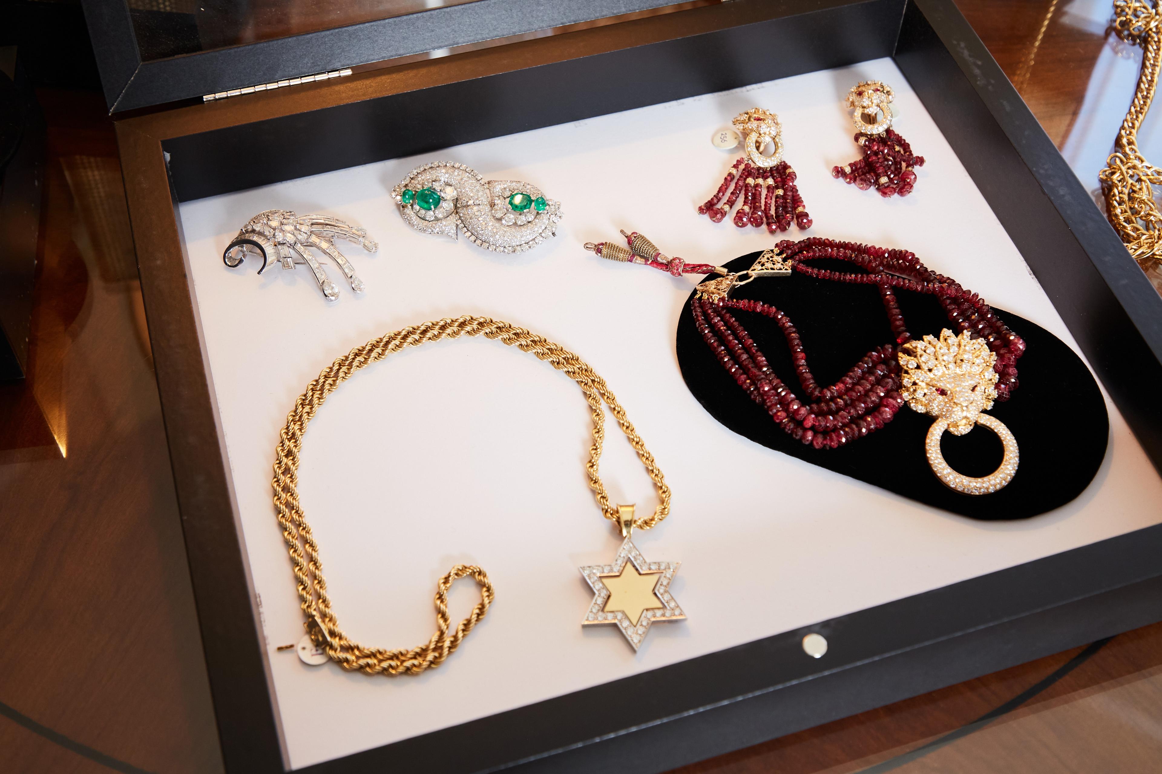 a display case filled with necklaces , earrings , and brooches .