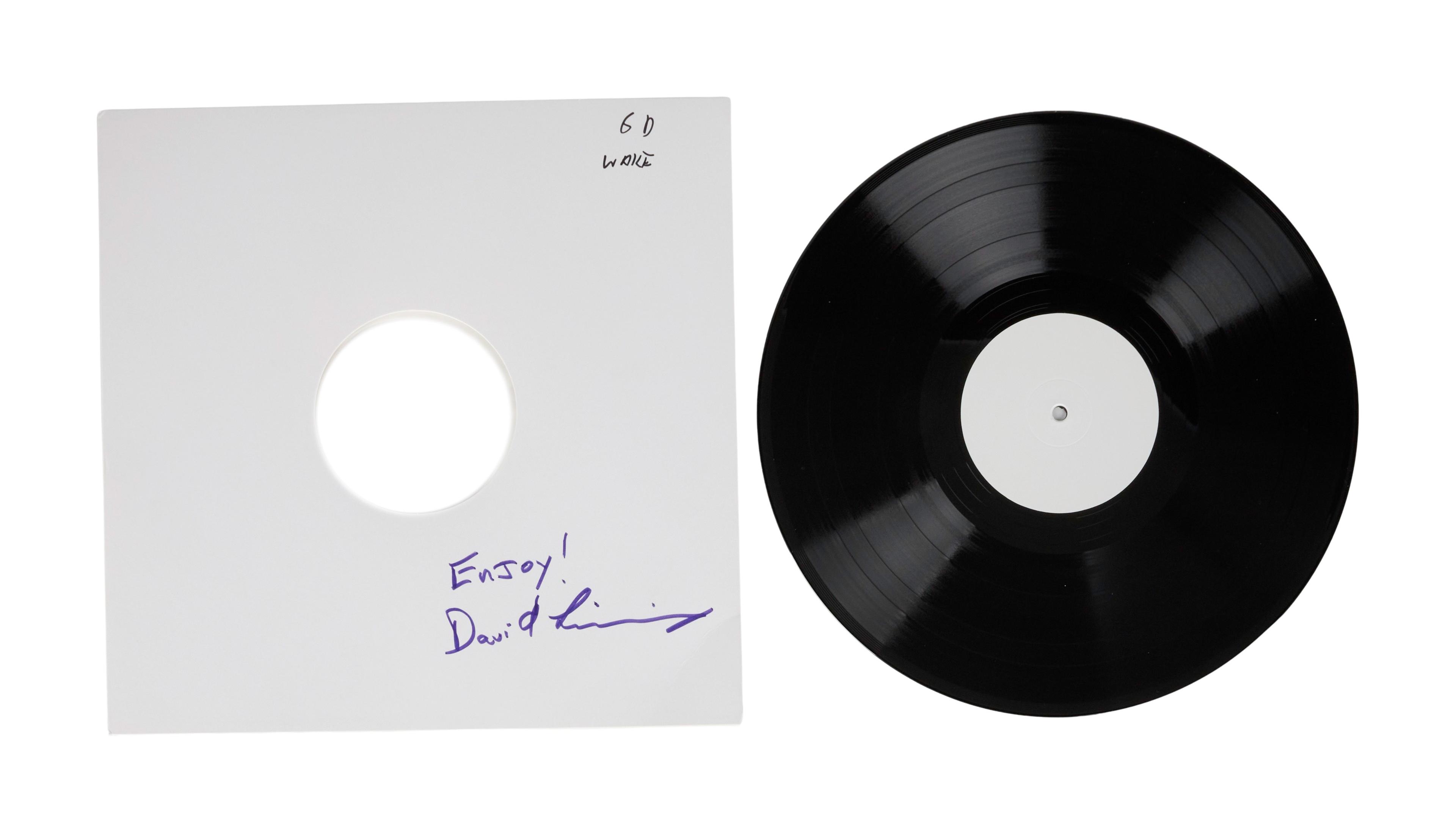 a black record is sitting next to a white record cover .