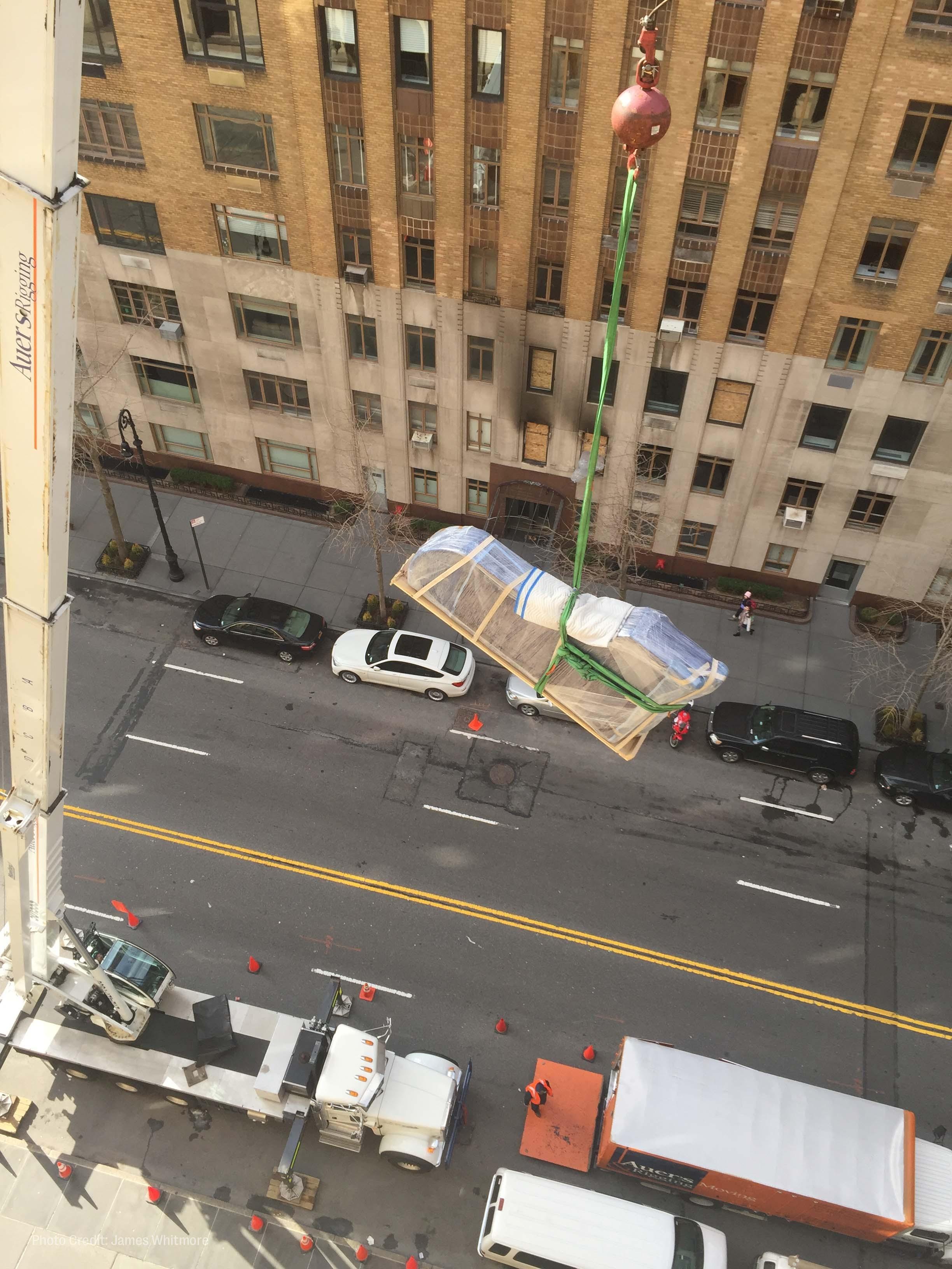 workers hoist roberta flack's piano out of her new york city apartment window.