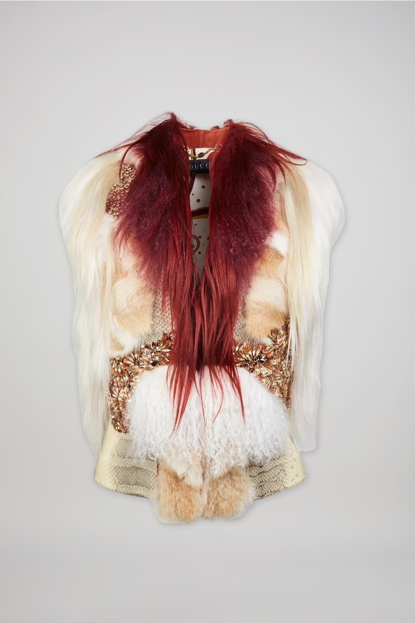 a white and red fur vest with the word gucci on it