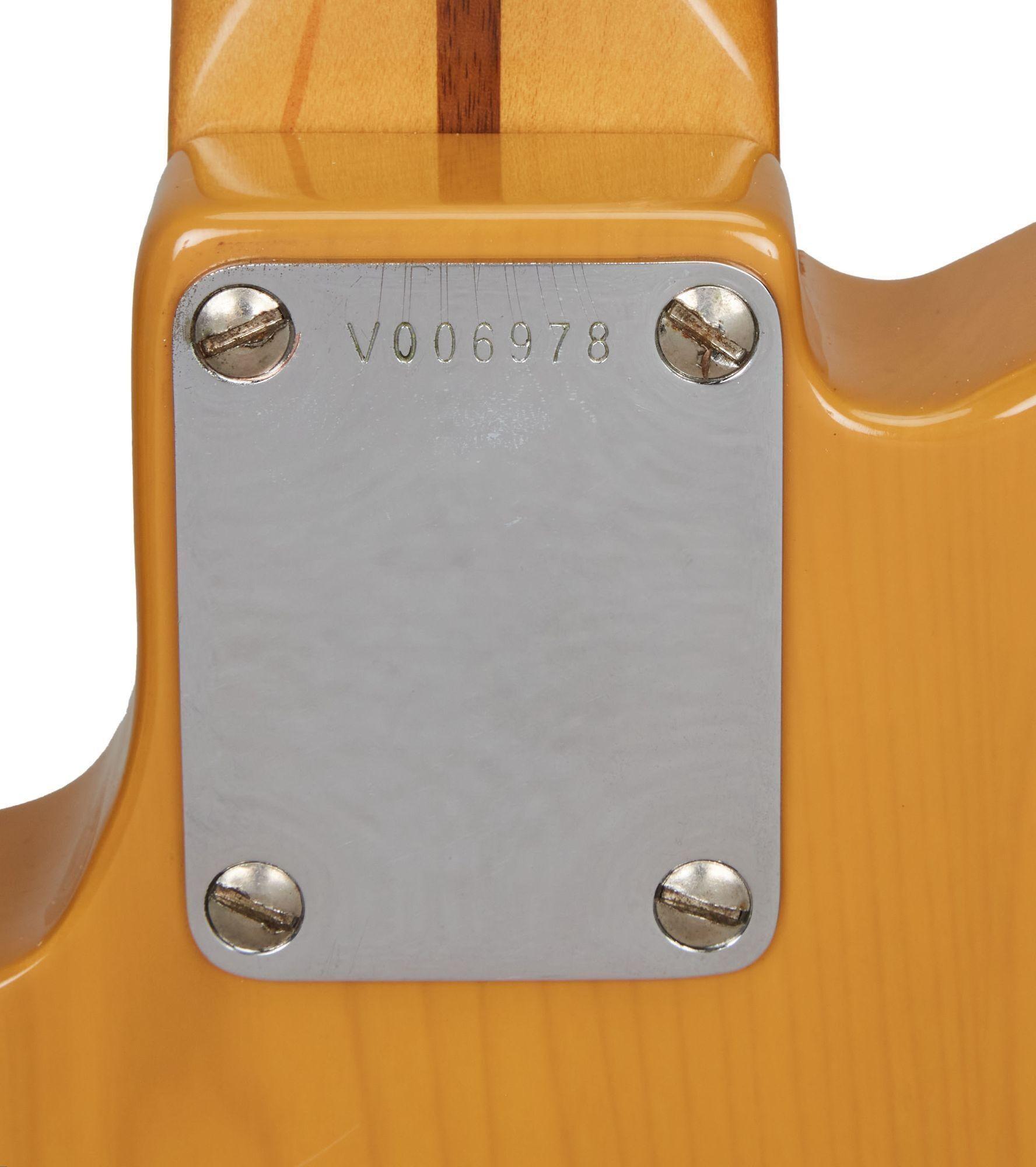 a close up of the back of a guitar with the serial number v006978