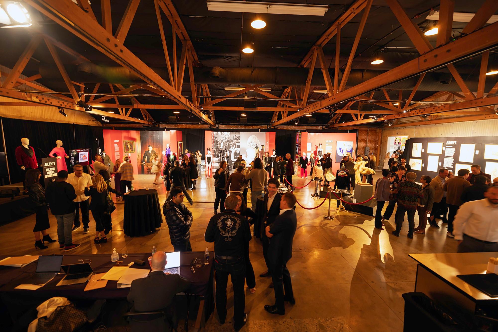 a large group of people are standing in a large room .