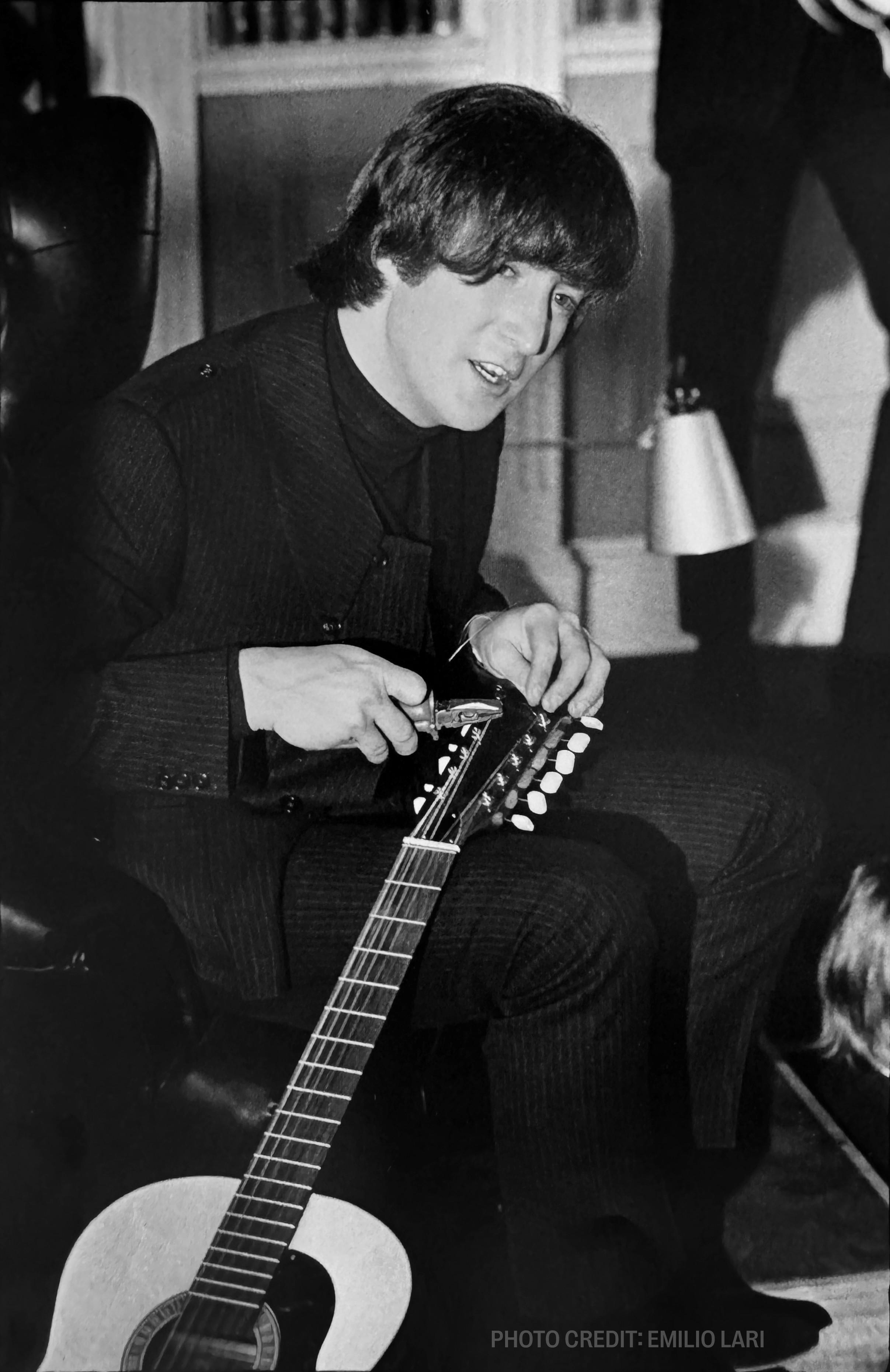 a black and white photo of a man playing a guitar