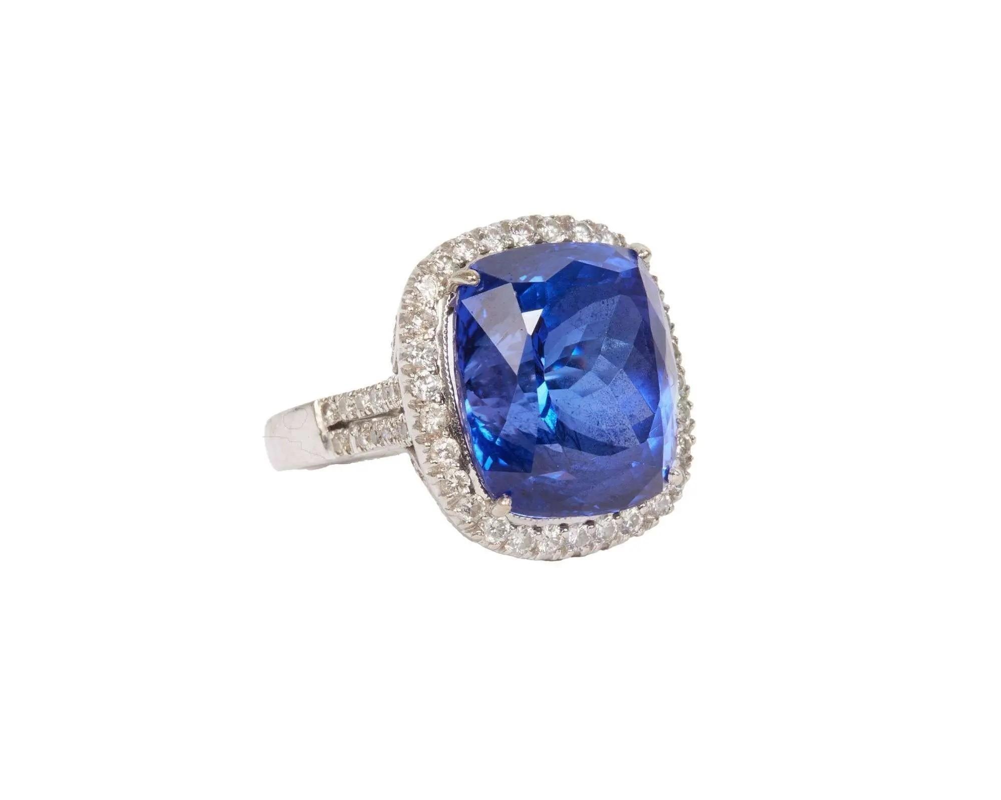 Lot #133. Whoopi Goldberg | 18k White Gold Tanzanite and Diamond Ring Cushion-cut blue sapphire ring with a diamond halo.