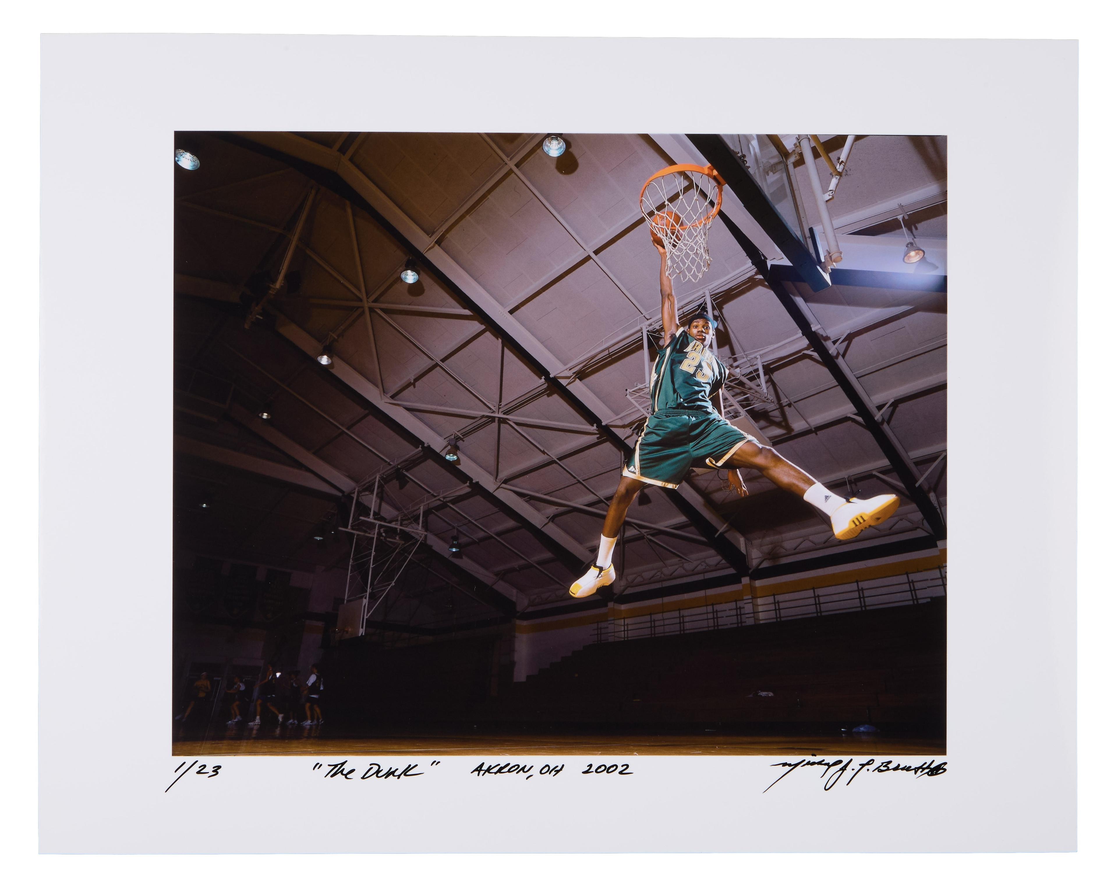 a basketball player is jumping in the air to dunk the ball .