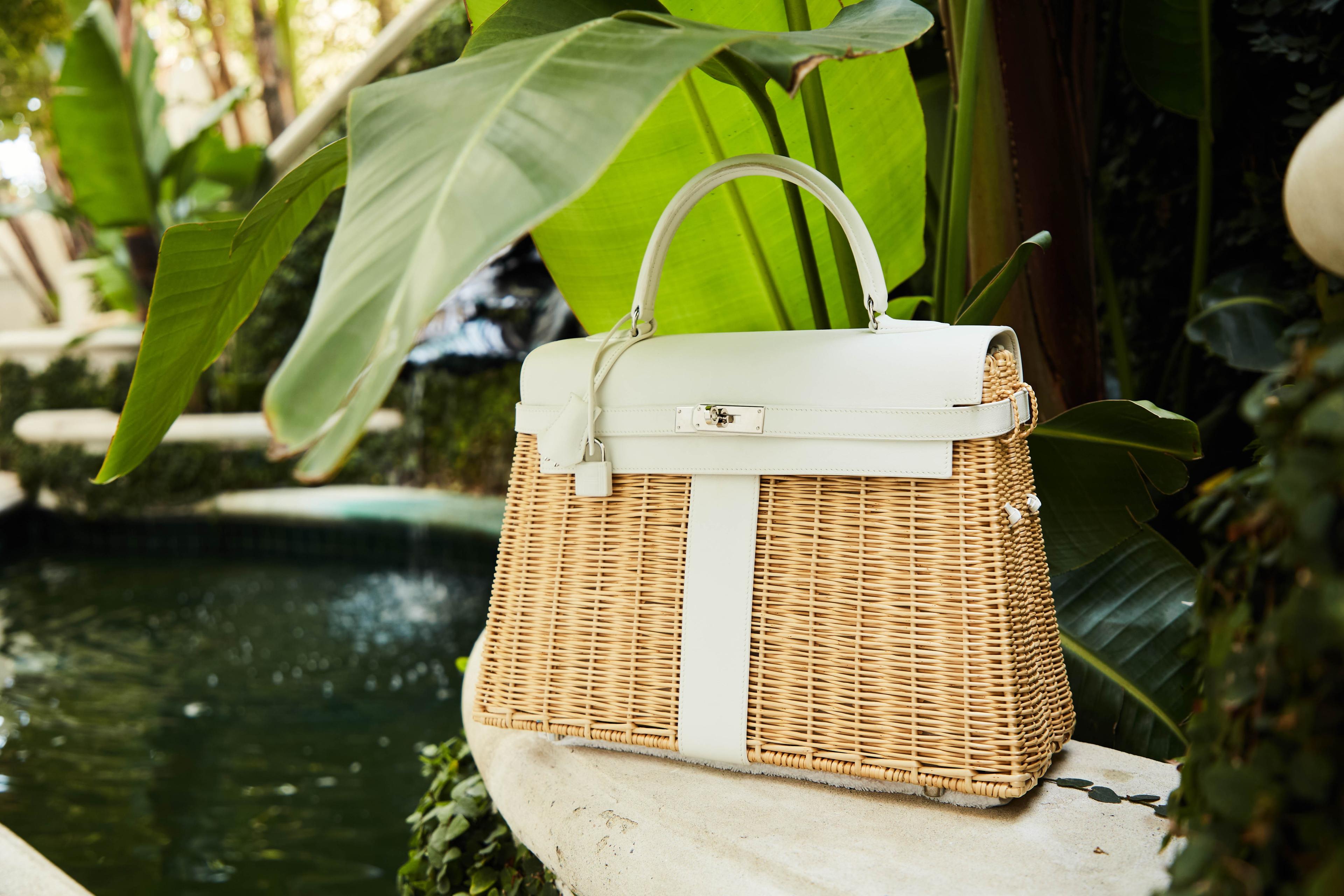 a wicker bag is sitting on a stone ledge next to a pond .
