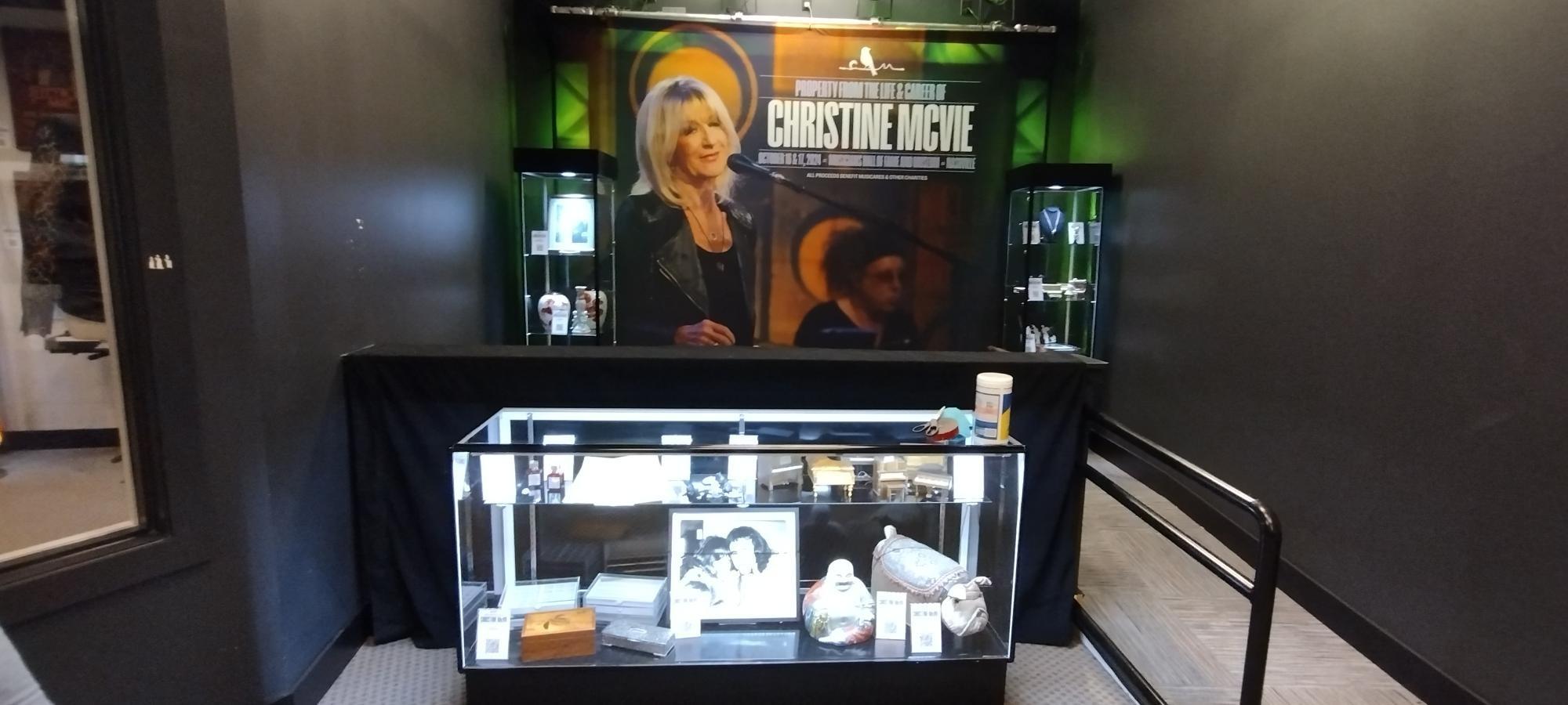 a glass display case filled with various items in a room .