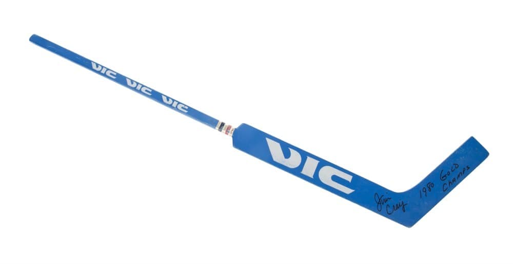 Blue hockey stick with VIC branding, signed on the blade "Jim Craig" and "1980 Gold Champs."