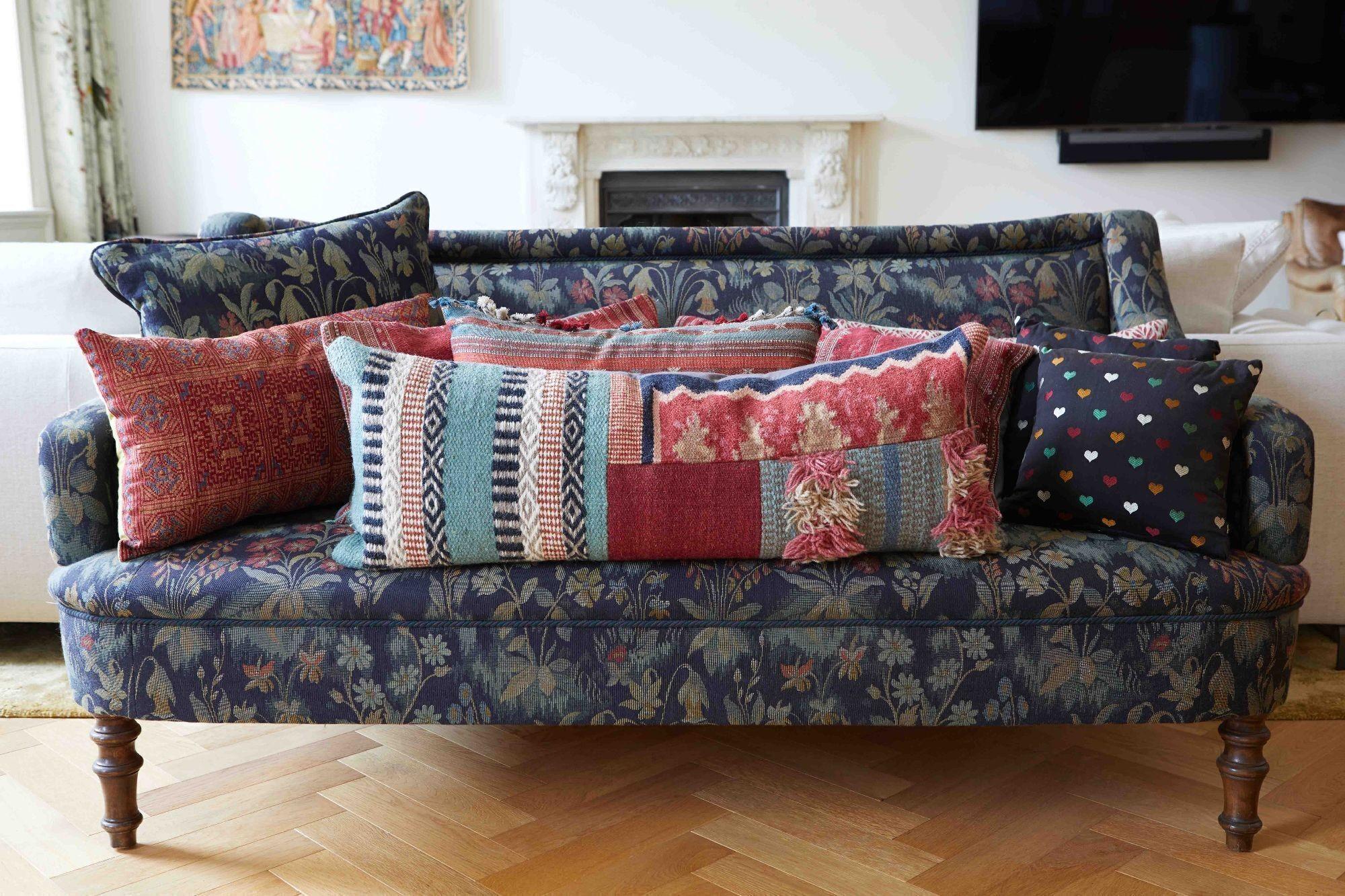 a couch with lots of pillows on it in a living room .