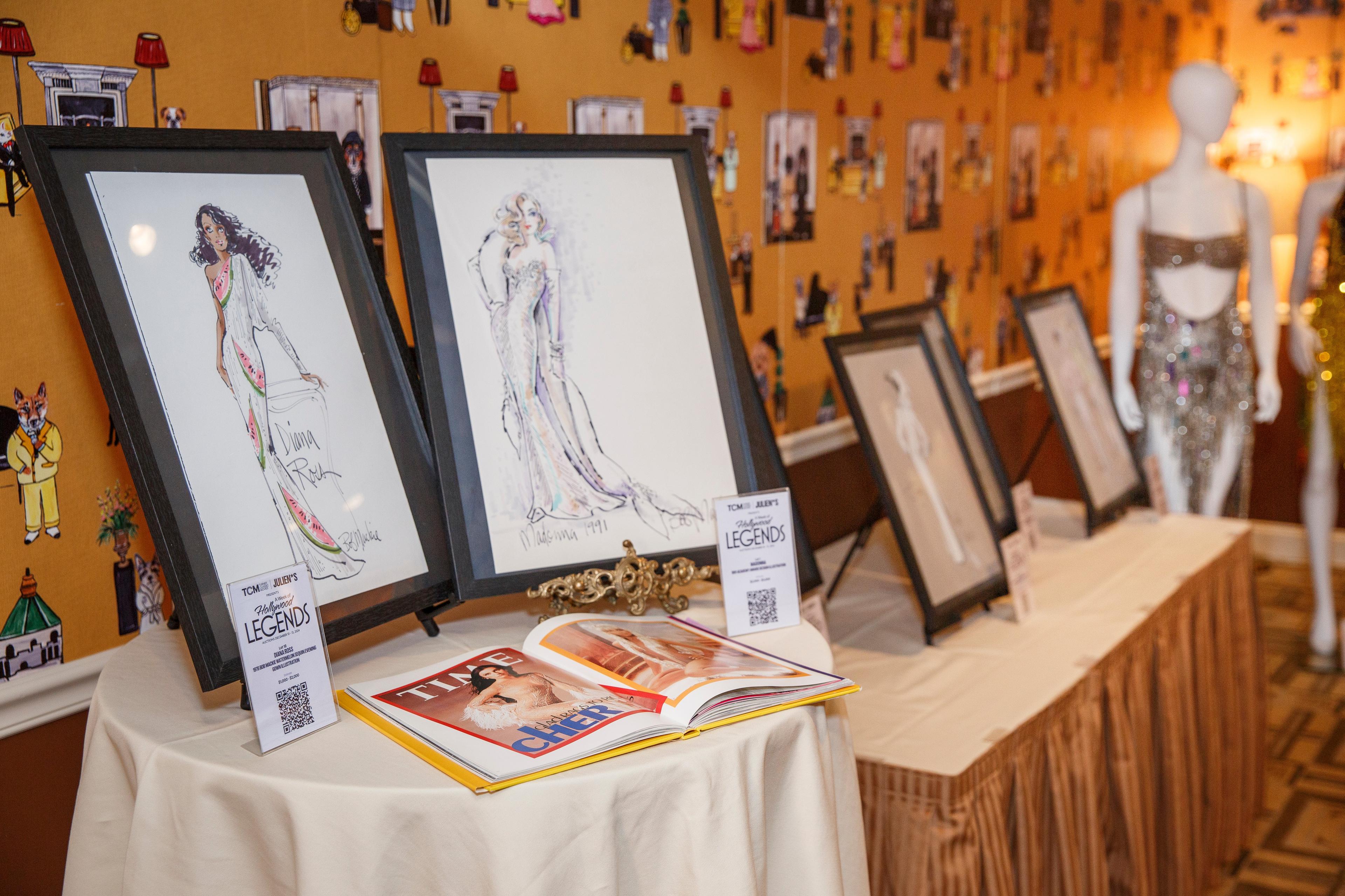 a table with a bunch of drawings on it and a book on it .