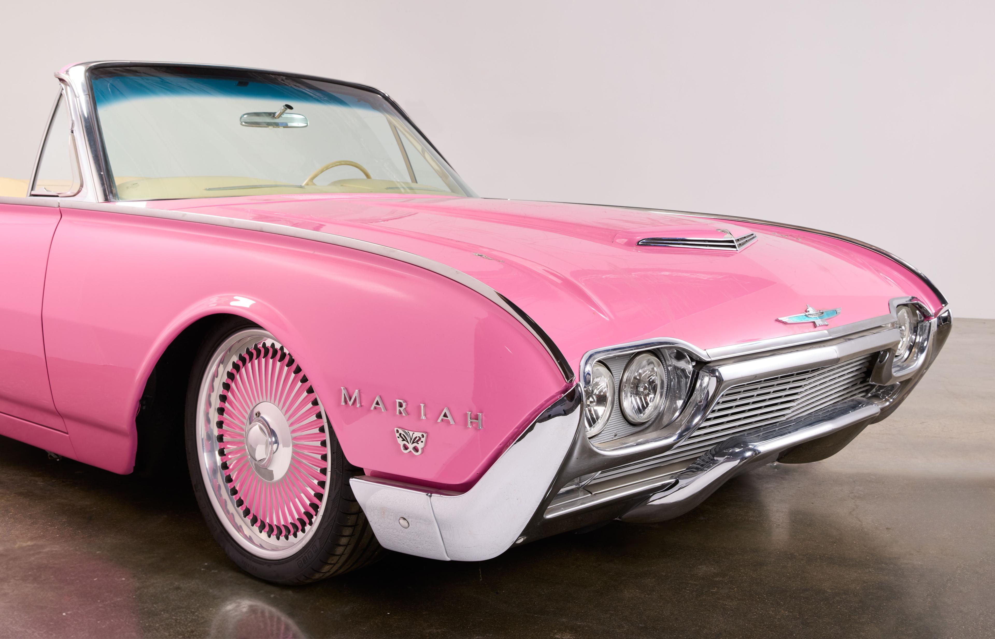 Pink custom Ford Thunderbird convertible with "MARIAH" on the fender and pink wire wheels.