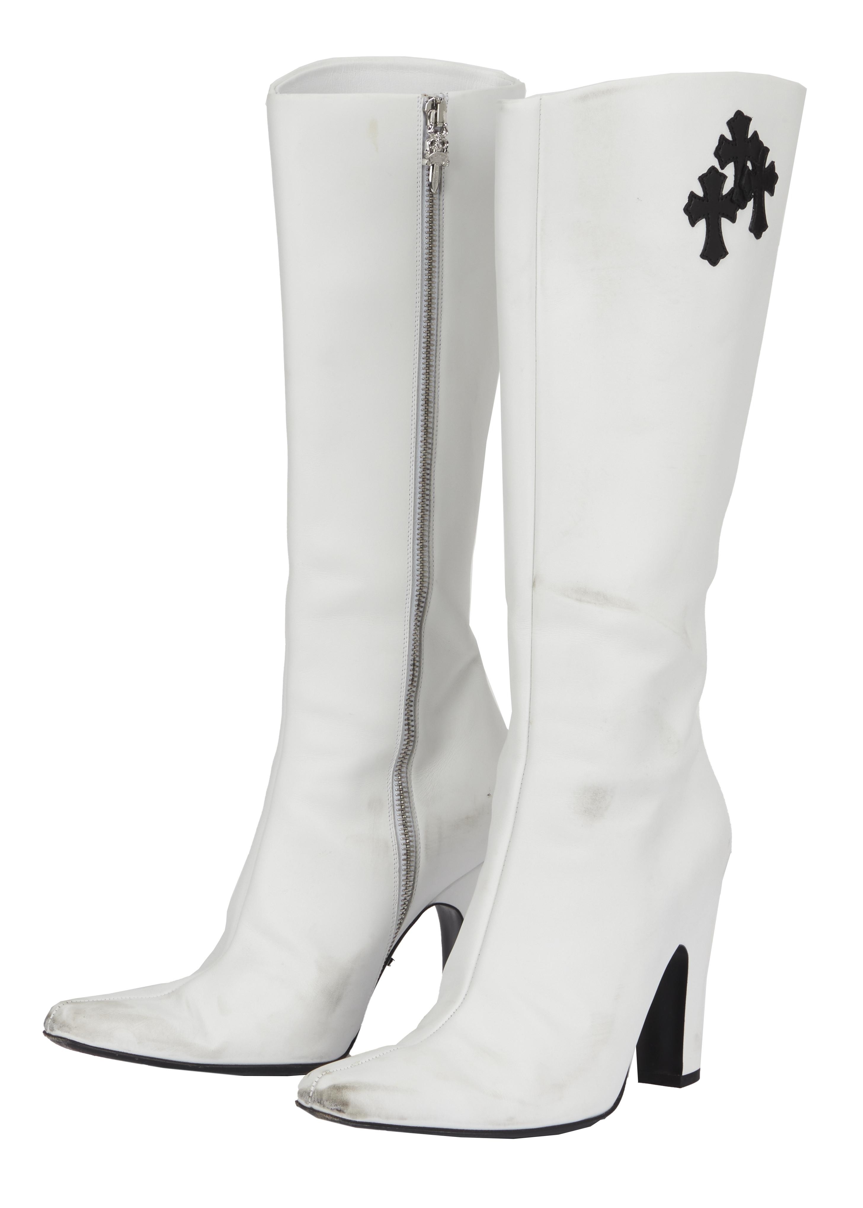 a pair of white boots with a black cross on the side
