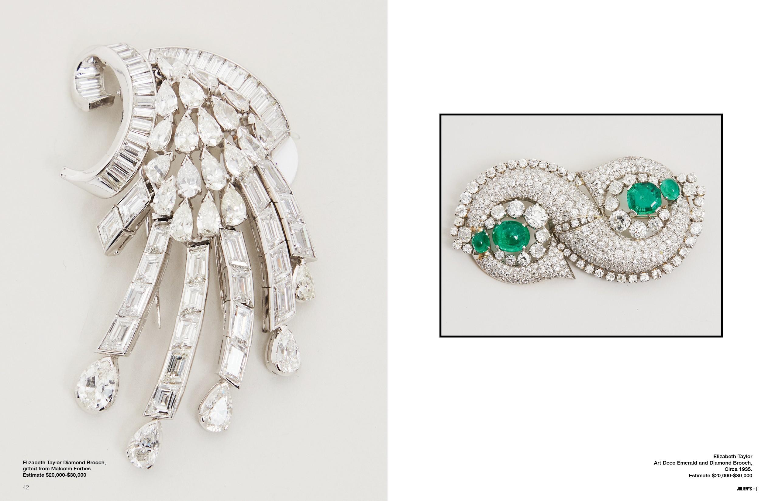 a brooch with emeralds and diamonds on a white surface .