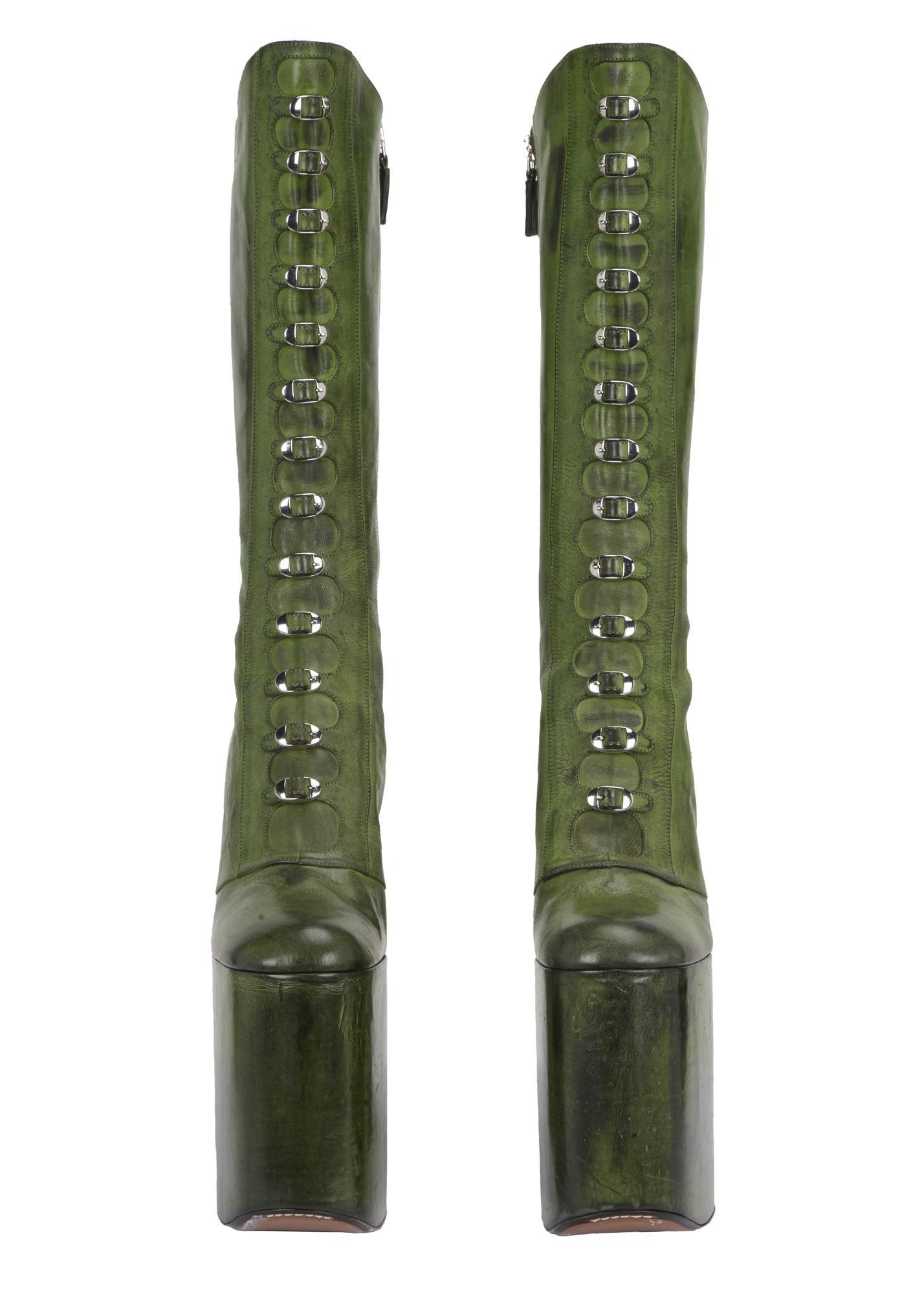 a pair of green lace up platform boots on a white background
