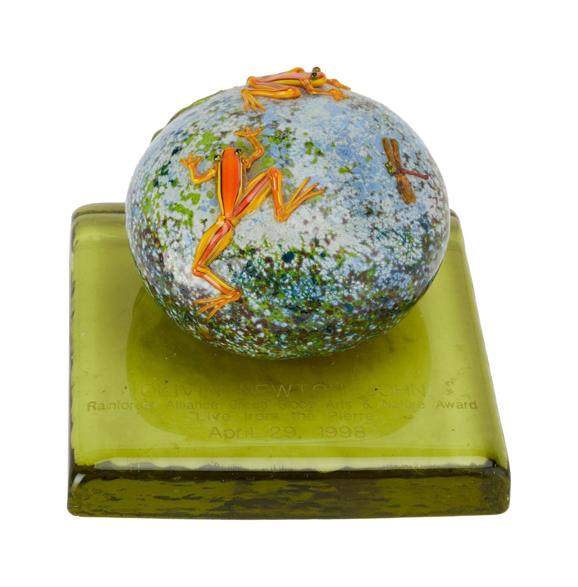 a glass ball with a frog and dragonfly on it