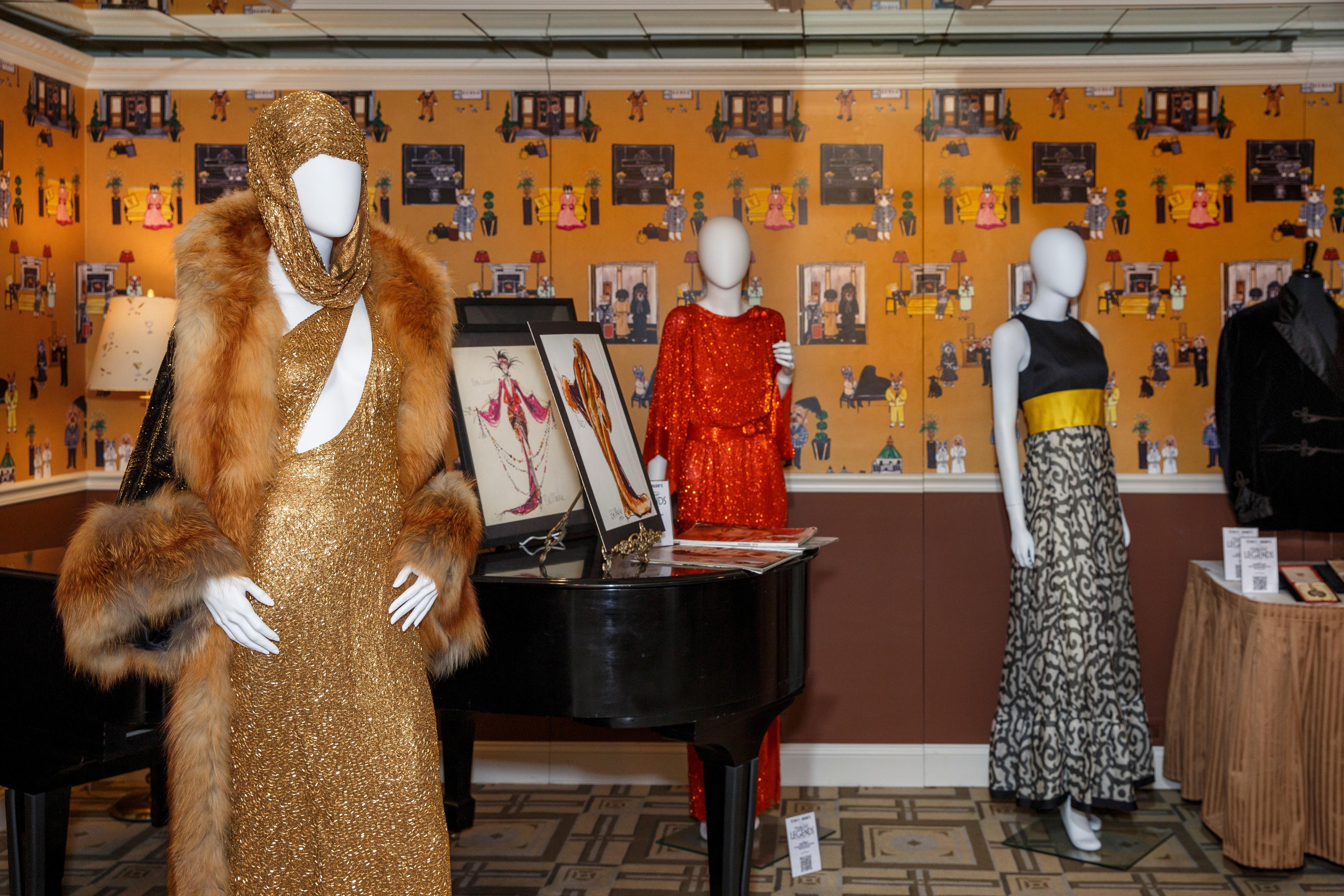 a group of mannequins are standing next to each other in a room with a piano .