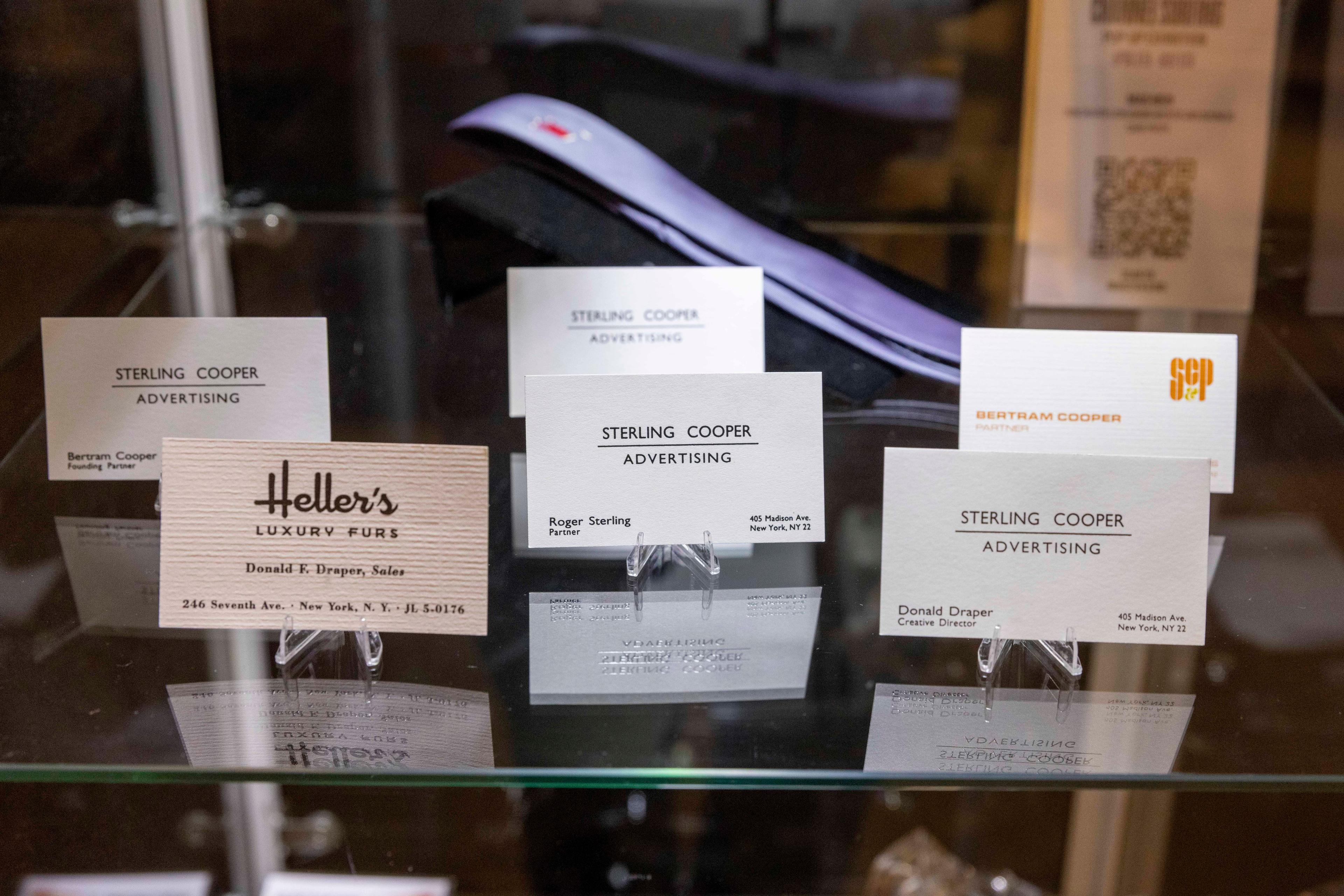 prop business cards from mad men enclosed in a glass casing