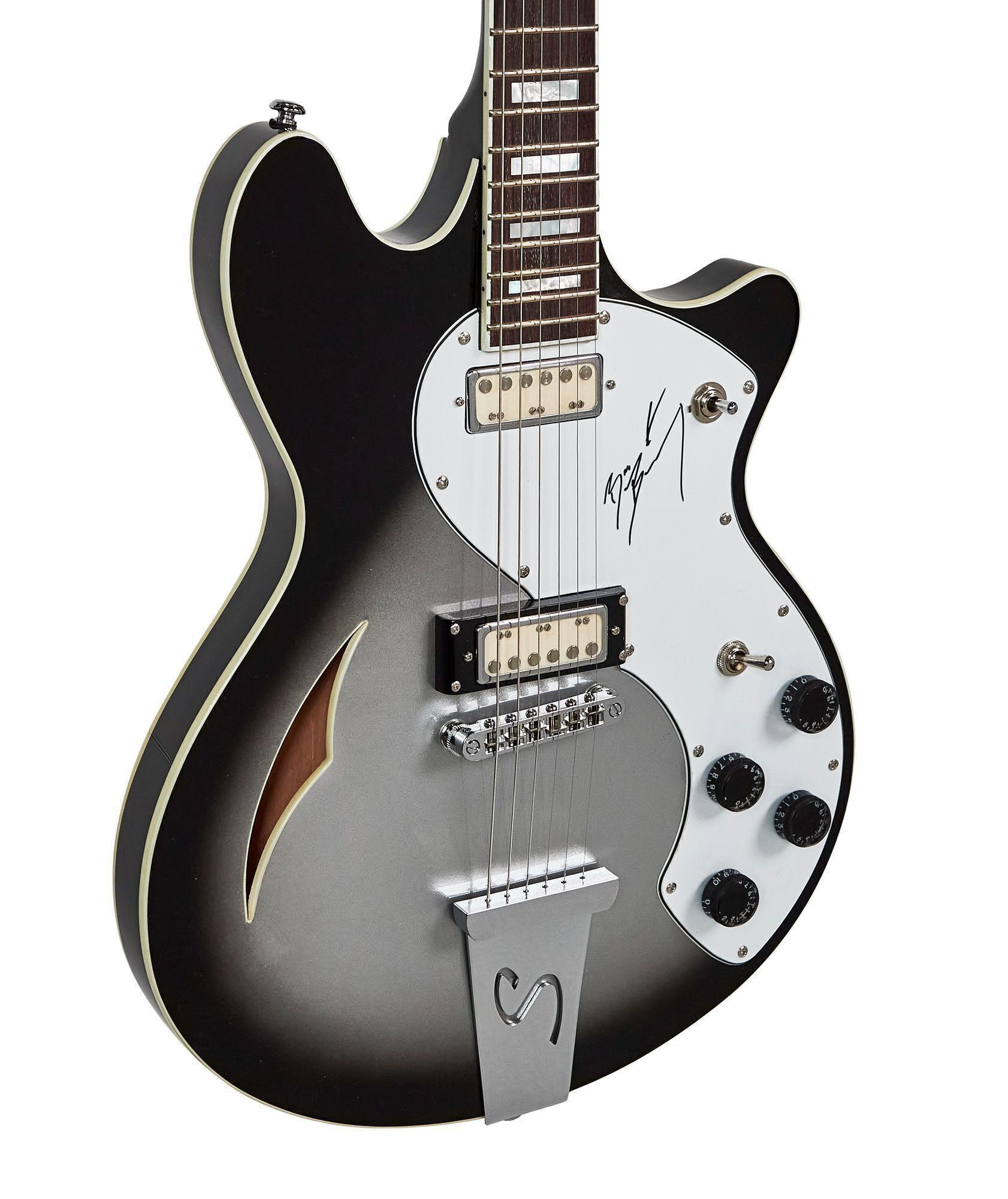 Black and silver burst semi-hollow electric guitar with white binding, a white pickguard featuring a signature, and chrome hardware.