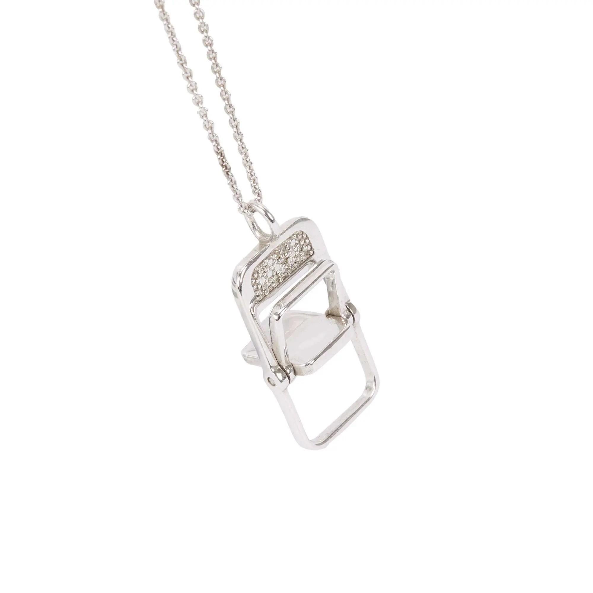 Silver necklace with a miniature folding chair pendant featuring diamonds on the backrest.