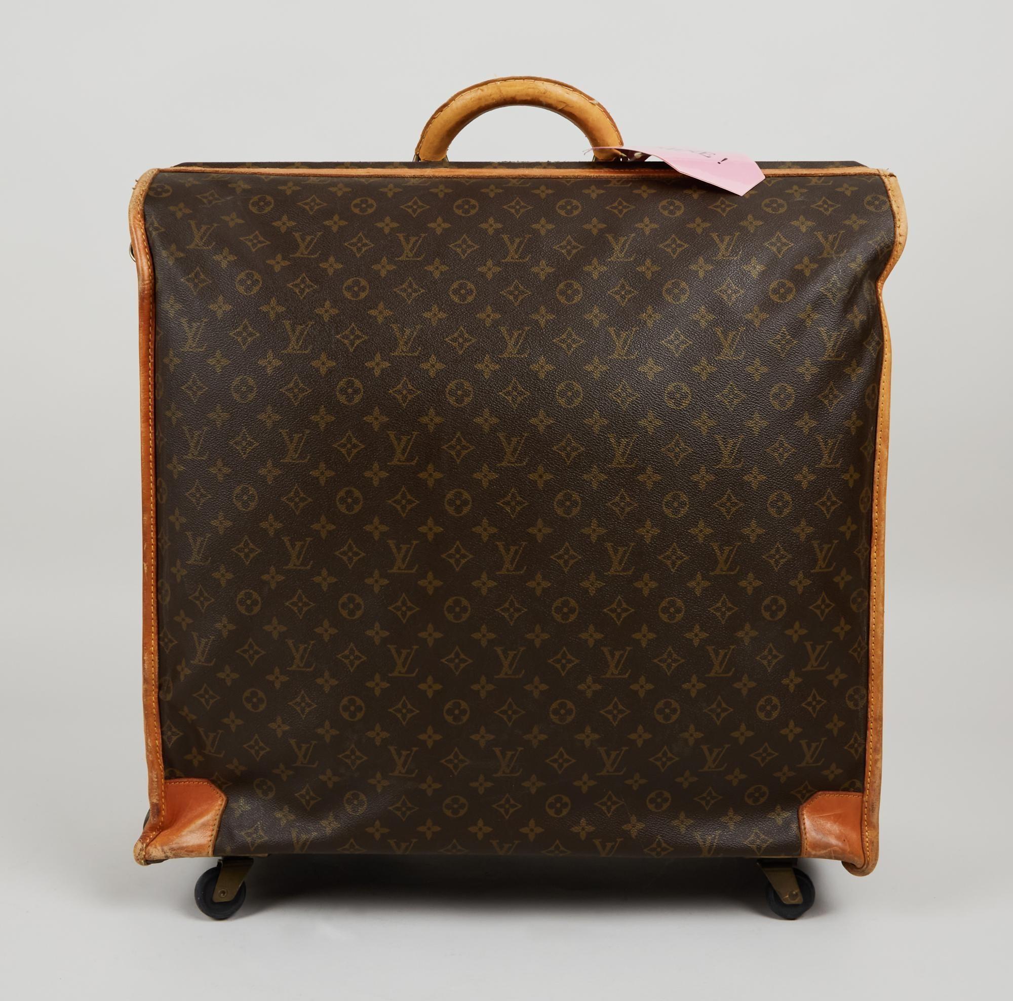 Lot #54. Elizabeth Taylor | French Company Louis Vuitton Monogram Luggage a brown louis vuitton suitcase with a wooden handle