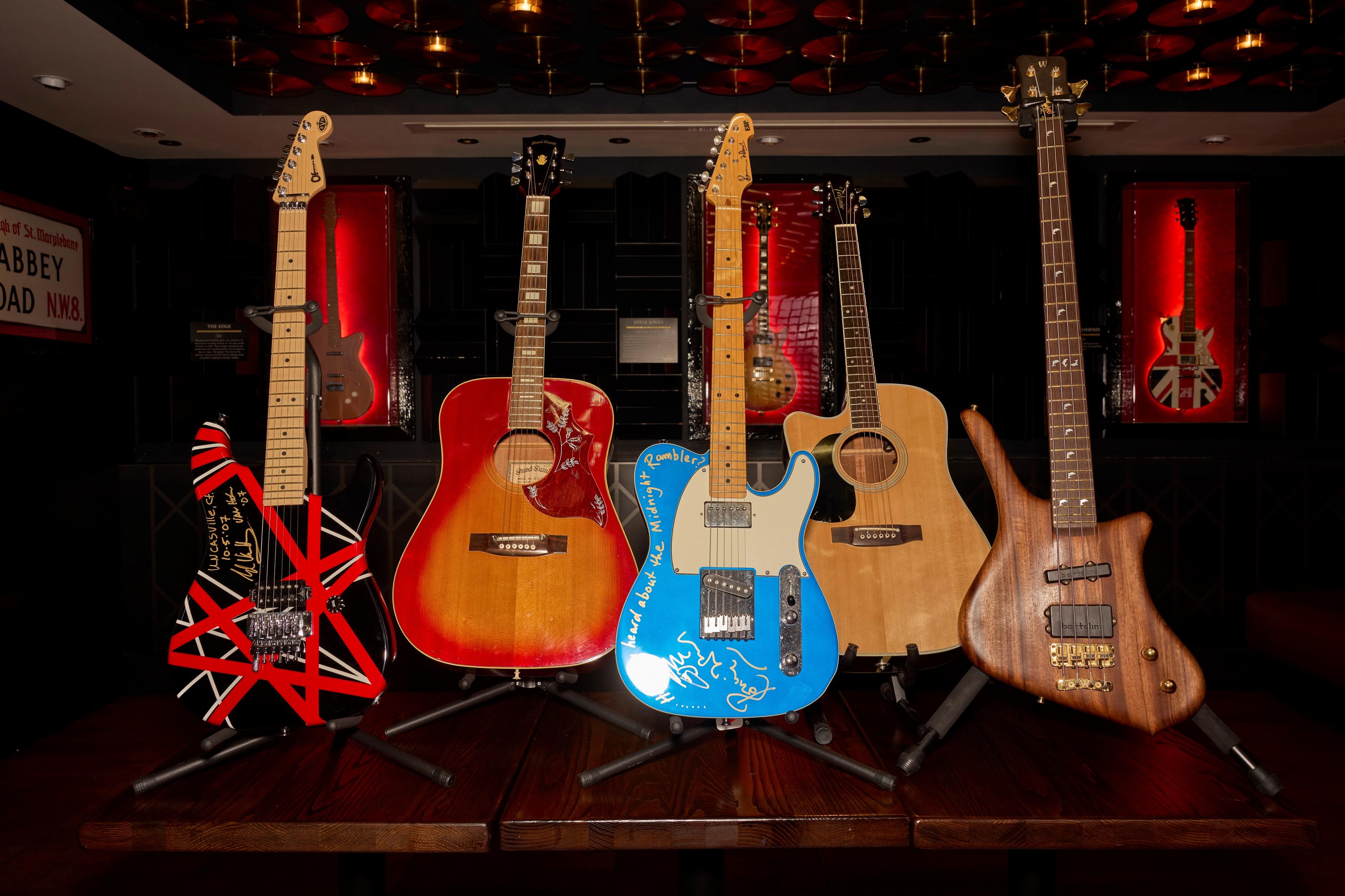 a collection of five guitars on display