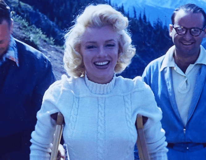 actress marilyn monroe is seen walking with crutches and smiling