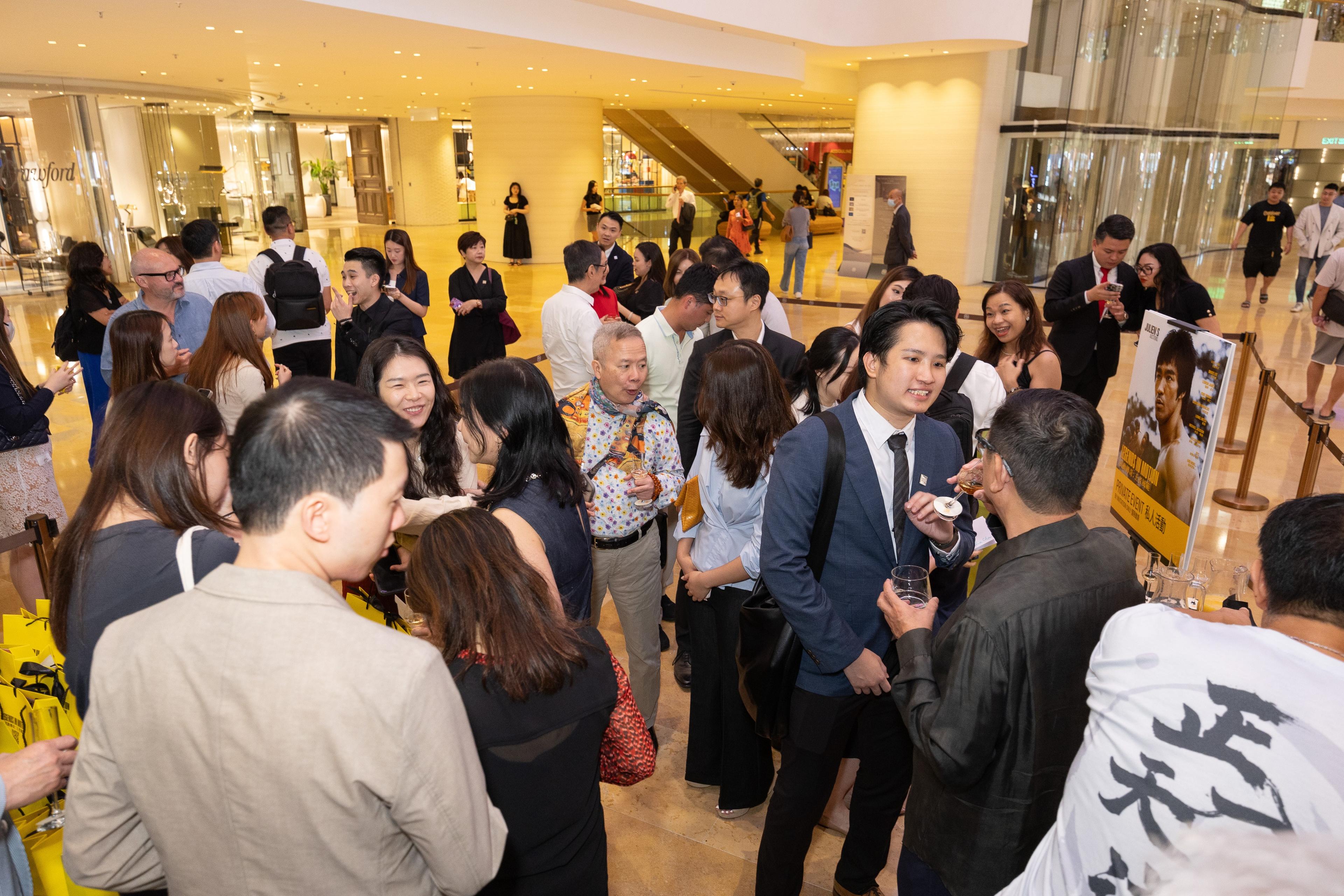 a large group of people are standing in a lobby of a building .