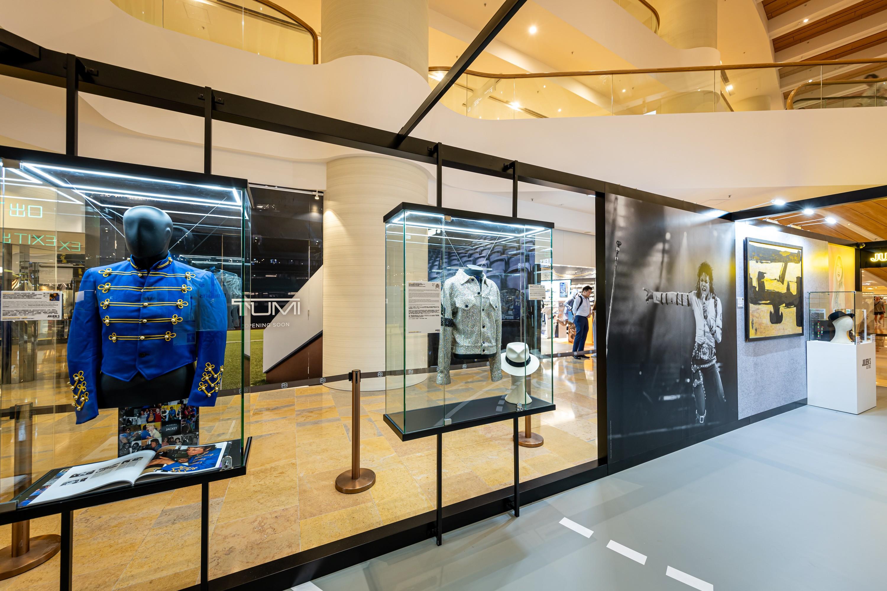 a display case filled with clothes and hats in a store .