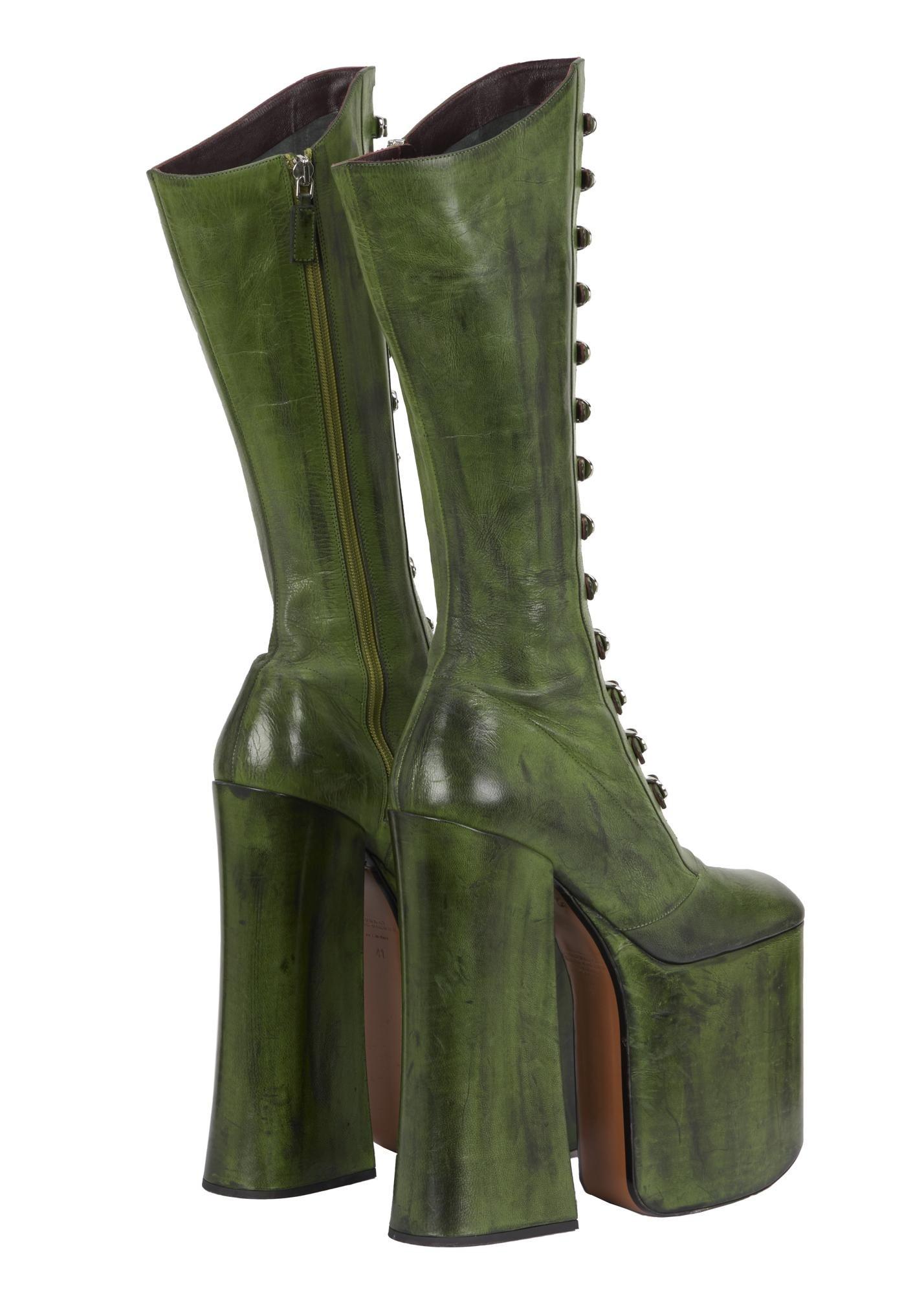 a pair of green platform boots with buttons on the side