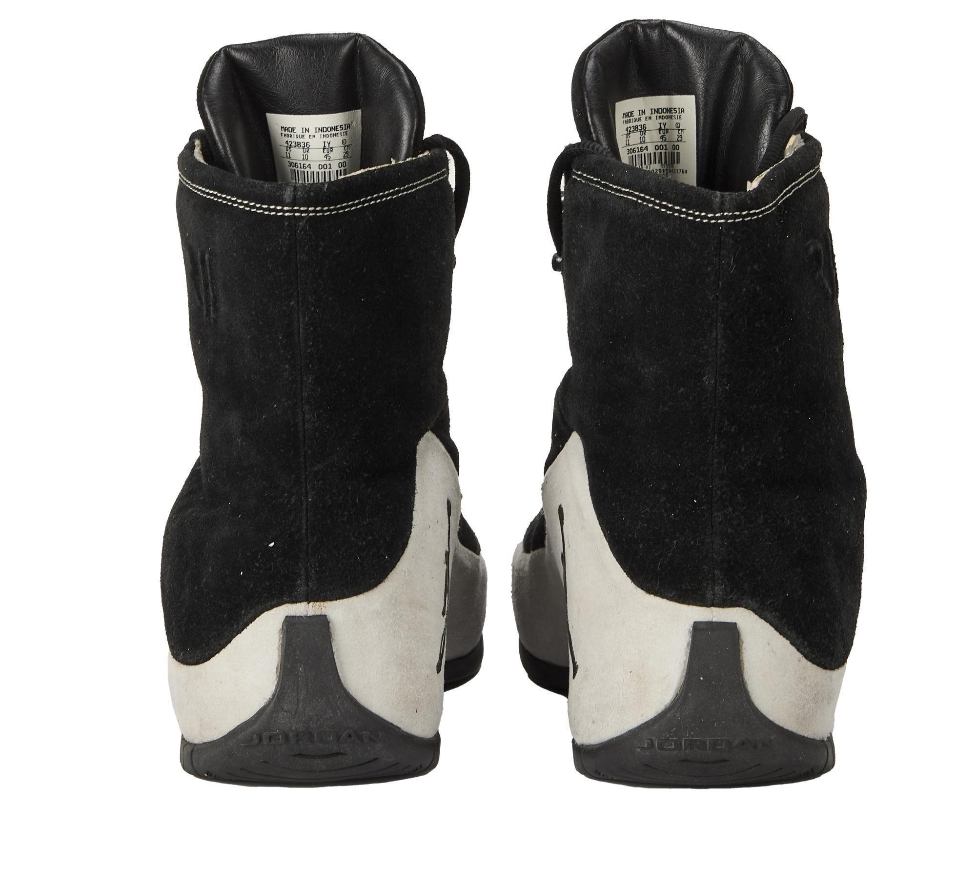 the back of a pair of black and white high top sneakers .