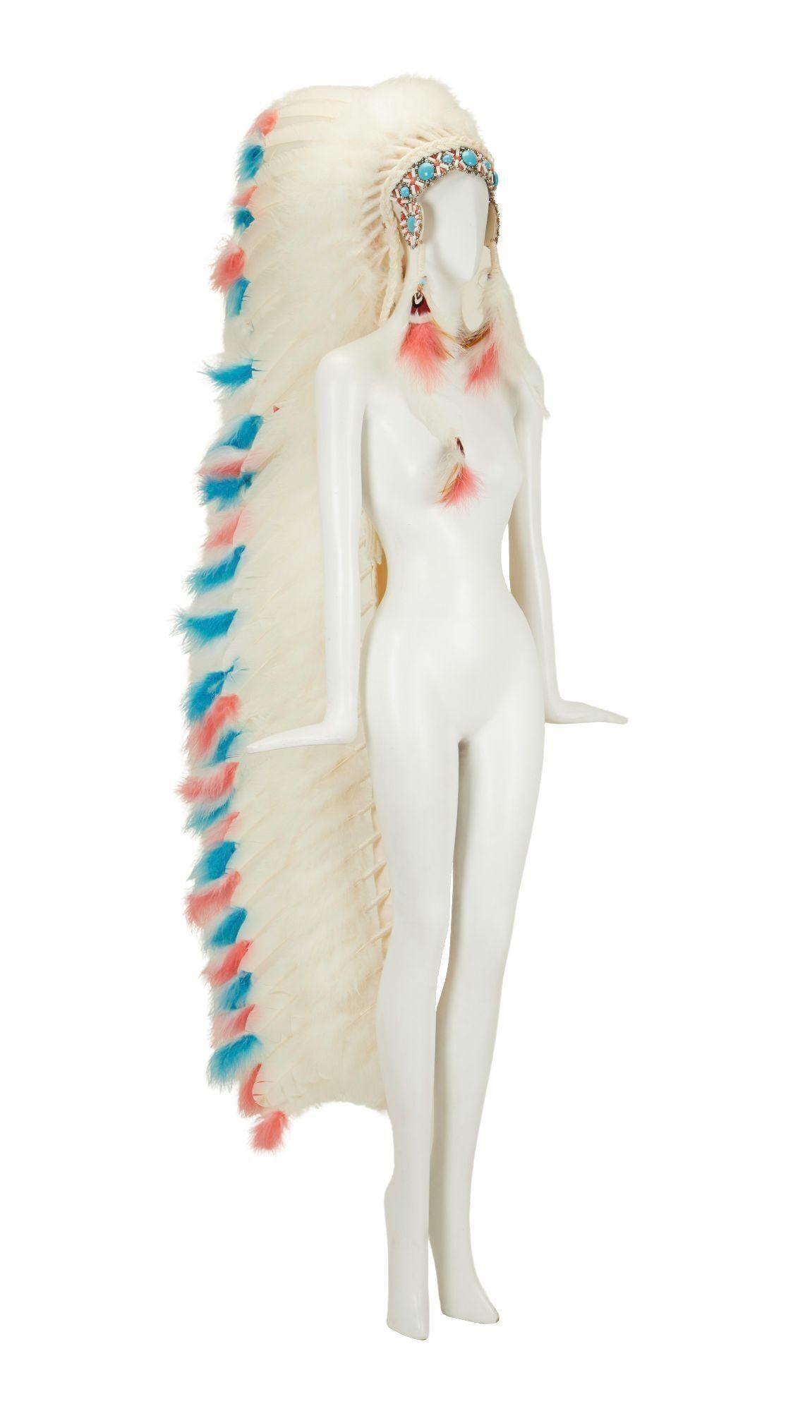 a white mannequin wearing a native american headdress