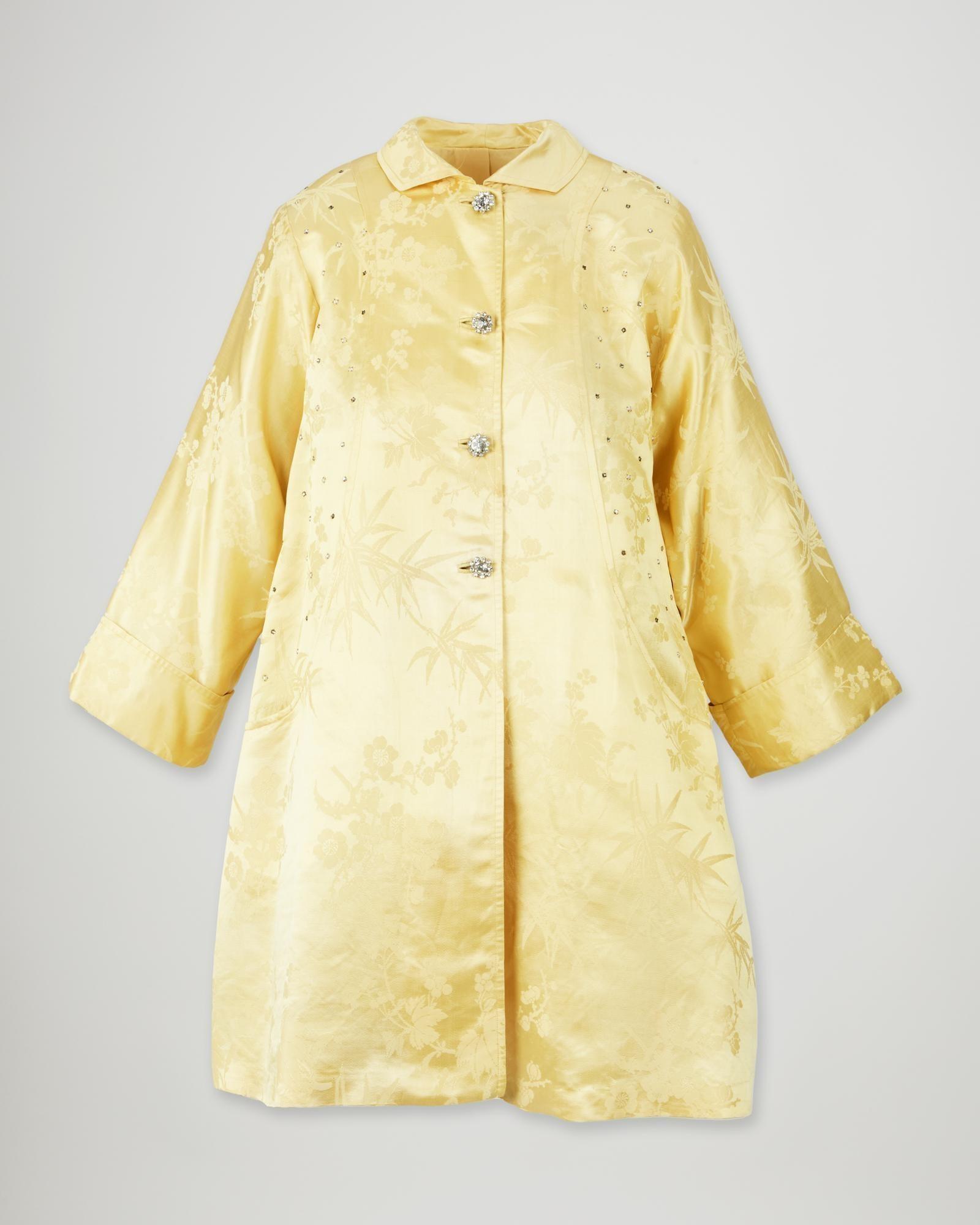 Lot #40. Elizabeth Taylor | Tina Lesar Yellow Silk Jacquard Embellished Evening Coat a yellow coat with a floral pattern and rhinestones on the sleeves