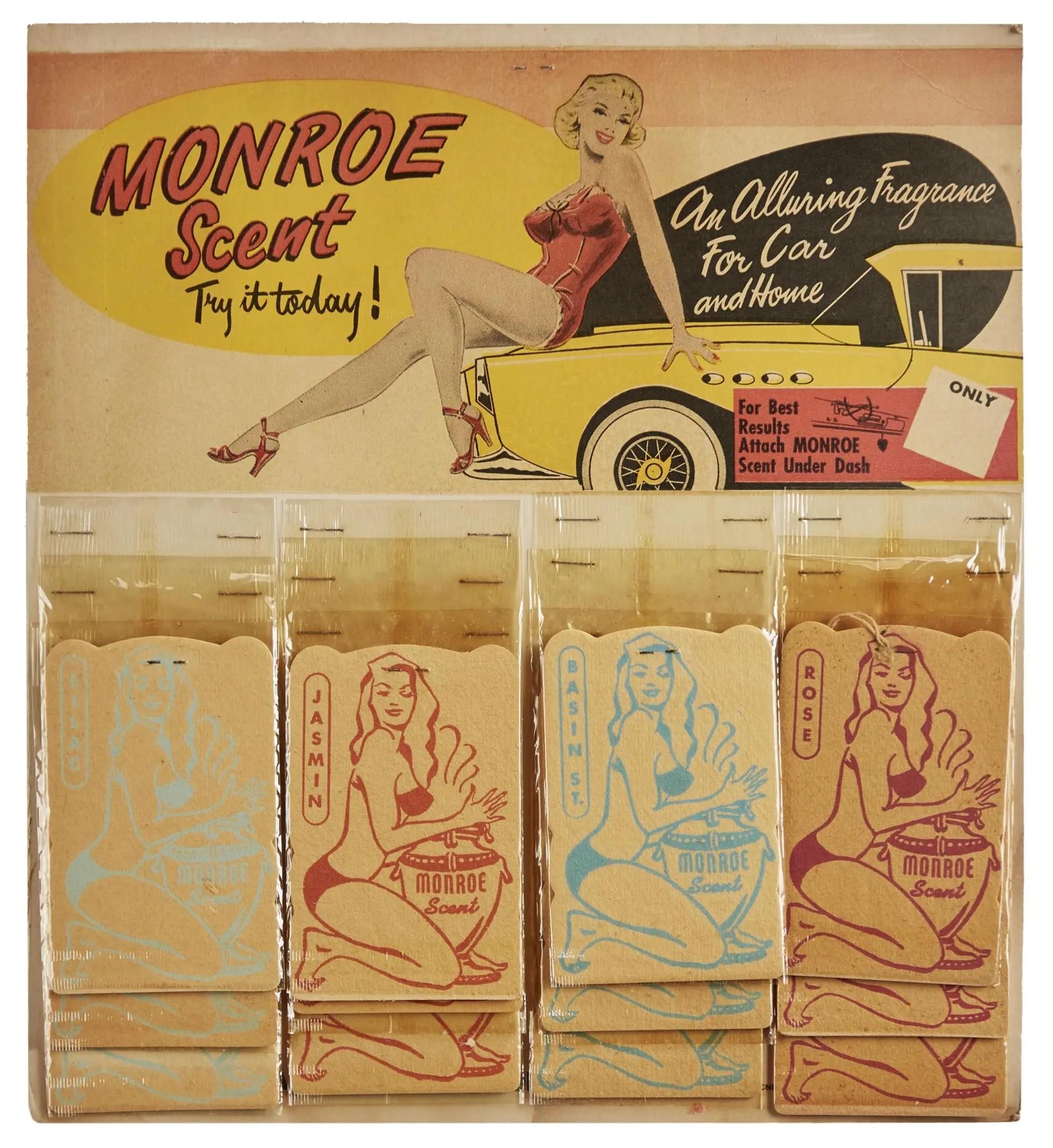 Lot #62. Marilyn Monroe | 1954 Vintage "Monroe Scent" Merchandising Display Vintage "Monroe Scent" air freshener display with a pin-up woman on a car in the header and multiple scent packets below depicting bikini-clad women with drums.