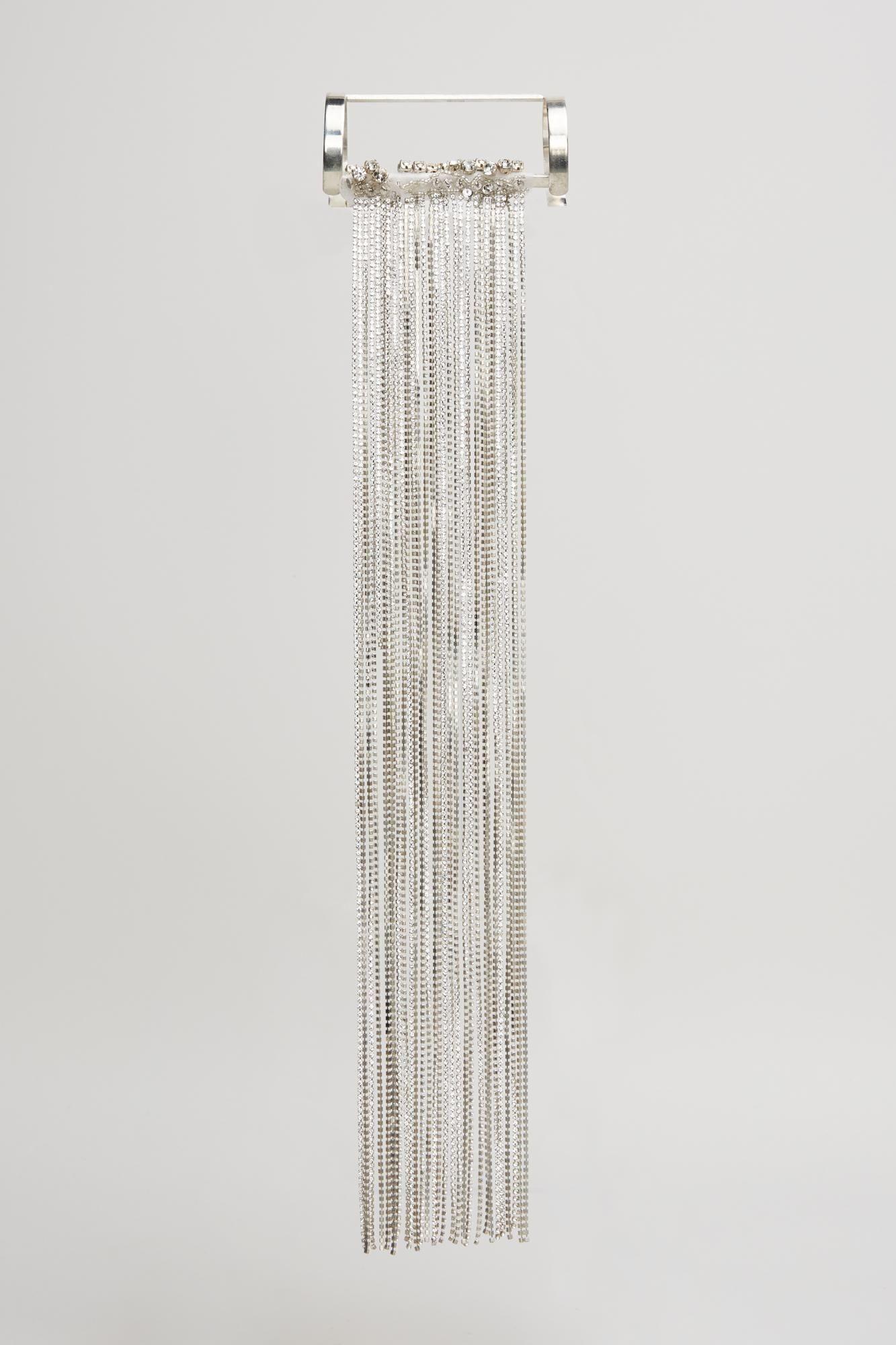 a silver fringe is hanging on a white wall